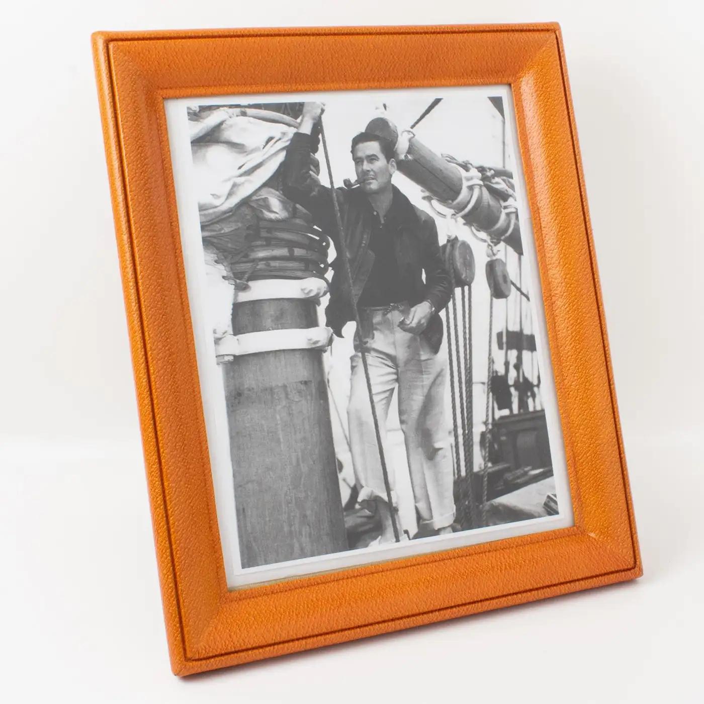 This Art Deco modernist leather picture photo frame was crafted in France circa 1940. The piece boasts fine-grain calf leather in a golden amber cognac color with a pattern. The easel and back are in decorative cognac suede paper and there is a