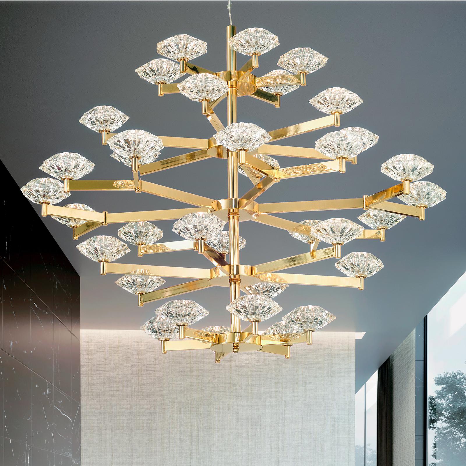 This exquisite chandelier is a superb object of functional decor that will illuminate a contemporary home while also adding a striking decoration that is both modern and lavish. The structure is crafted of brass with a soft gold finish and comprises
