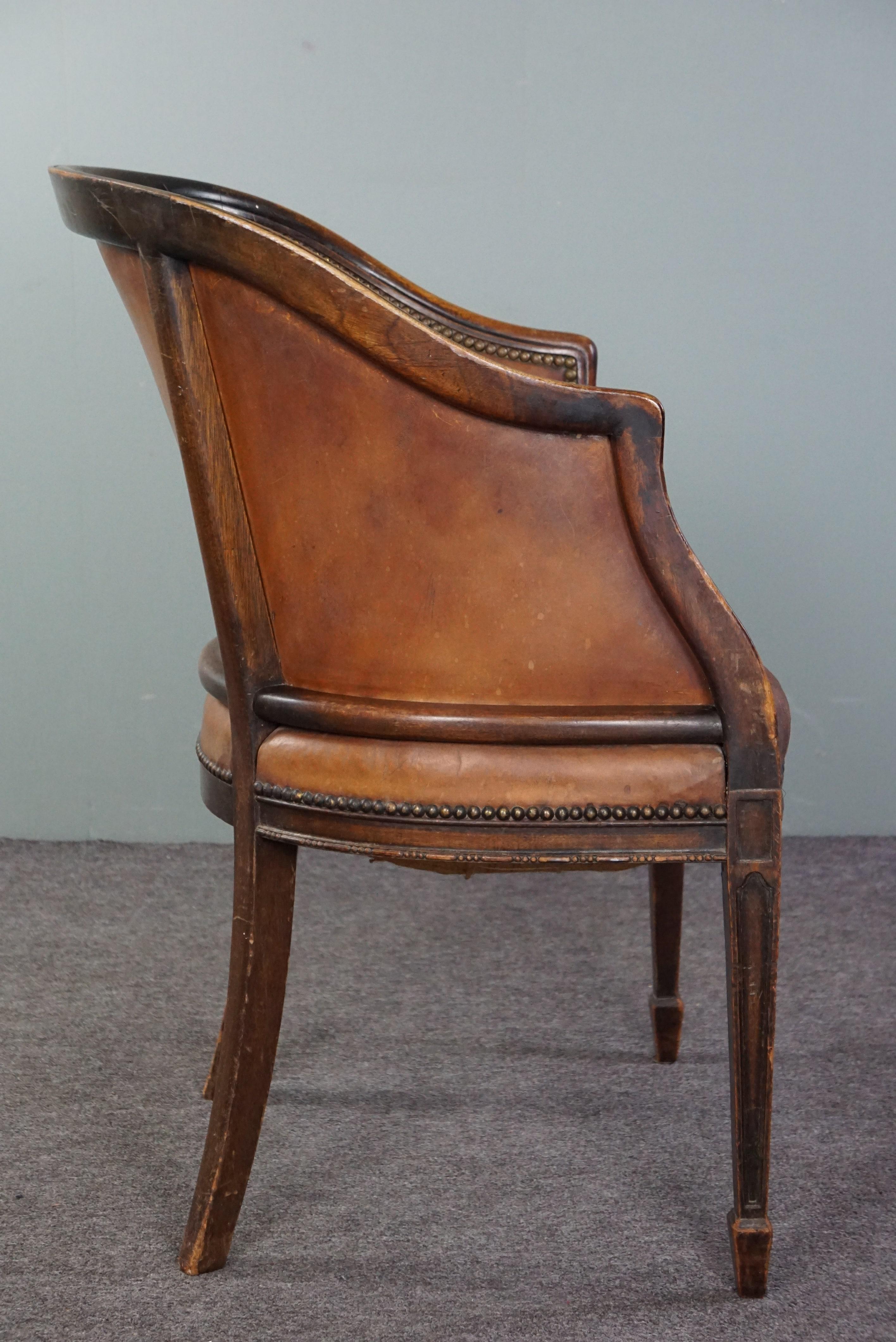 Early 20th Century Cognac-colored antique leather tub chair with beautiful patina For Sale