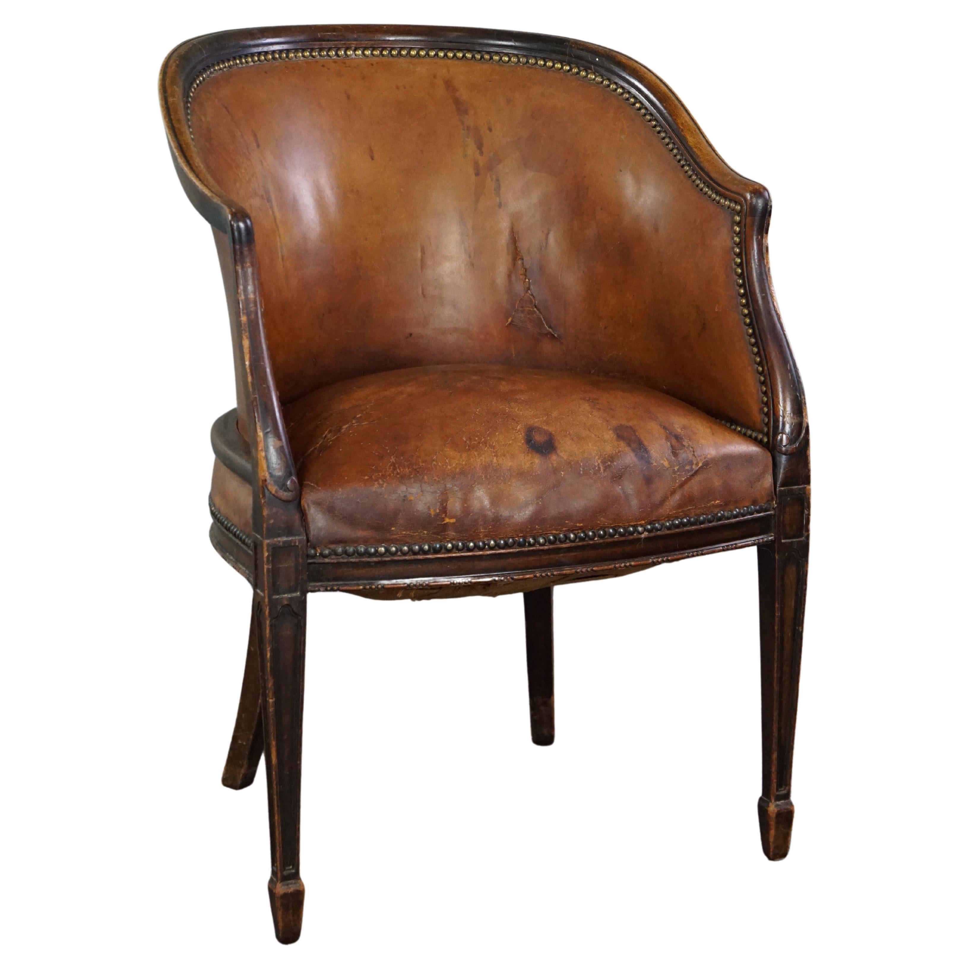 Cognac-colored antique leather tub chair with beautiful patina For Sale