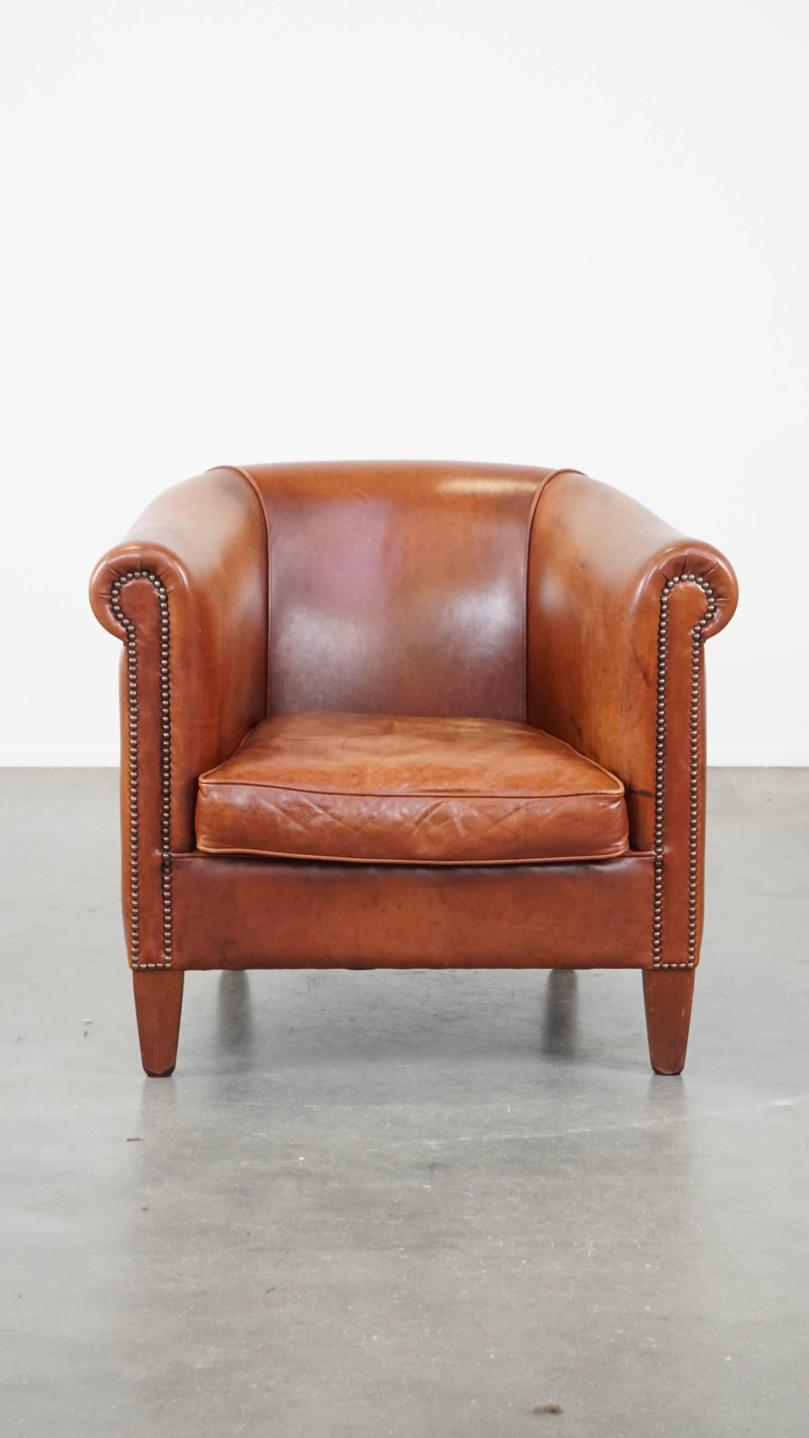 This wonderful cognac-colored cow leather club armchair, with its timeless design and comfortable seat, is the perfect place to relax after a long day. It features a removable cushion and is finished with decorative nails. Due to years of use, it