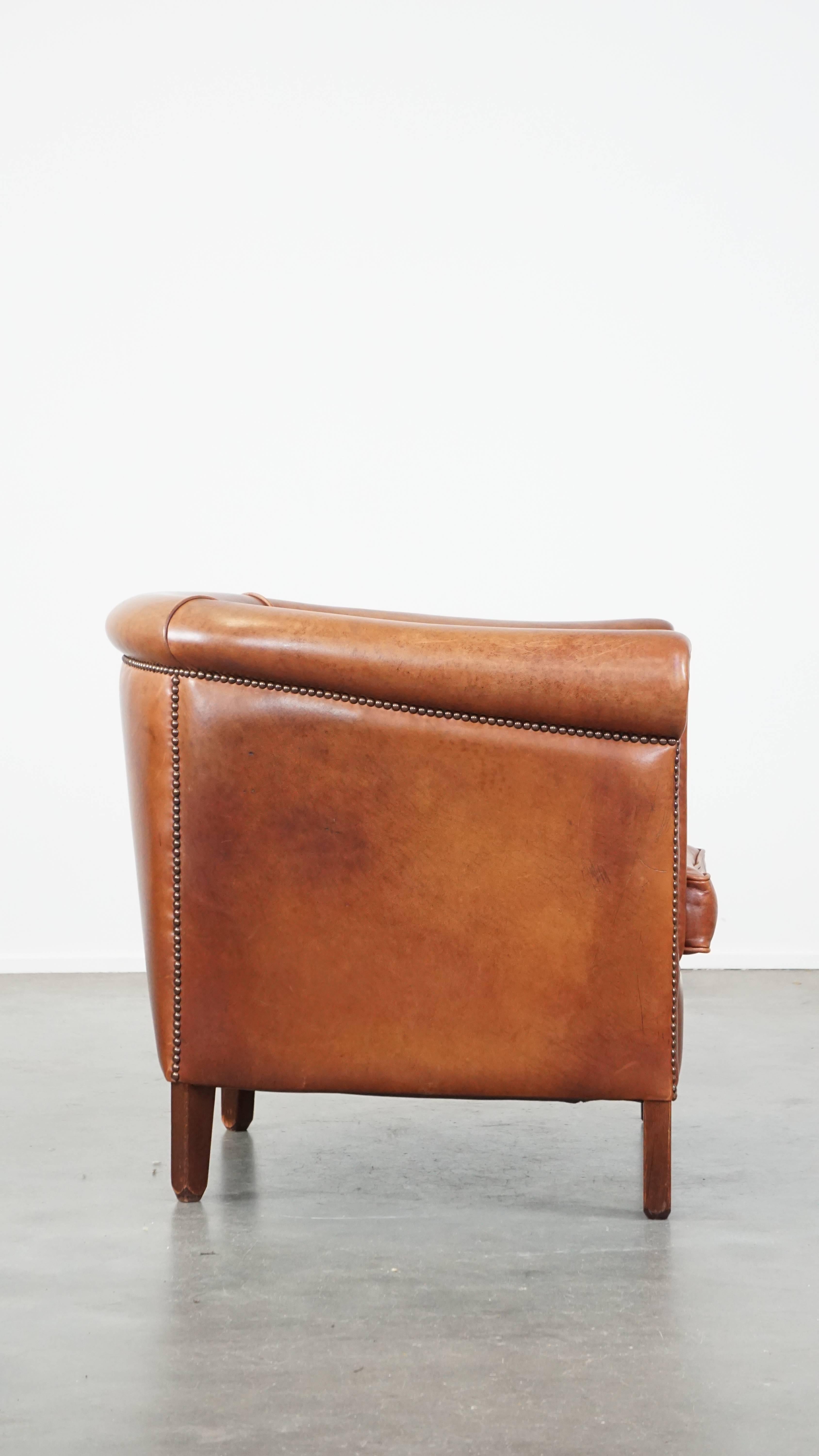 Hand-Crafted Cognac-colored English cow leather club chair finished with decorative nails For Sale