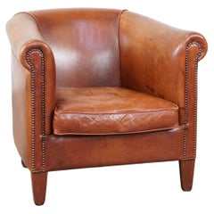 Fauteuil club anglais en cuir de vache de couleur cognac avec clous décoratifs
