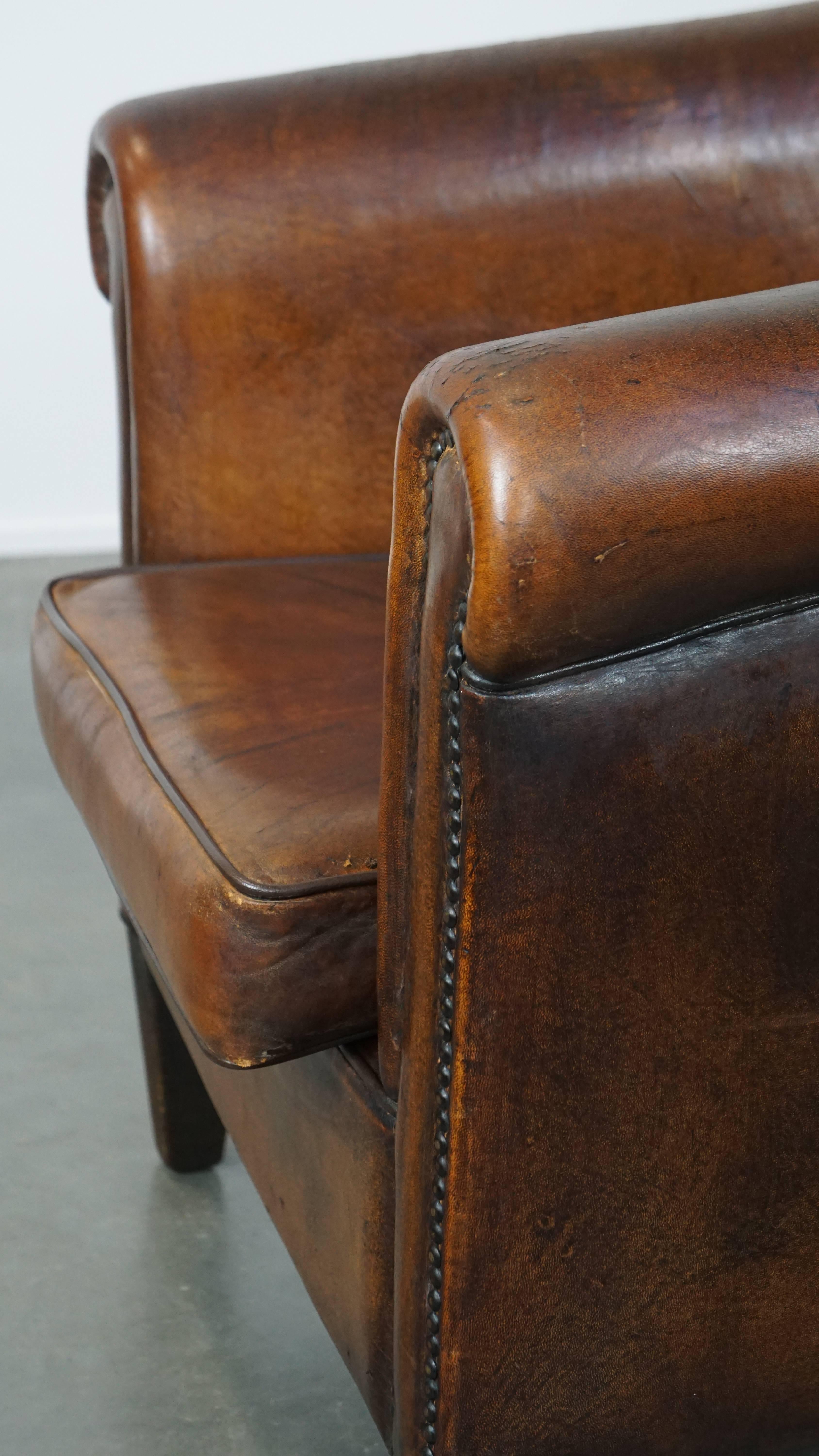 This stunning sheepskin leather club armchair is a true eye-catcher. Its fantastic English charm and rugged appearance make it impossible to resist. It is finished with decorative nails and has a beautiful cognac color. This club armchair features a