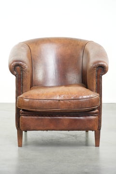 Cognac-coloured sheepskin club chair with a vintage look in English style