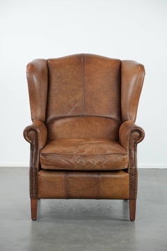 Sillón orejero de estilo inglés en piel de vacuno color coñac