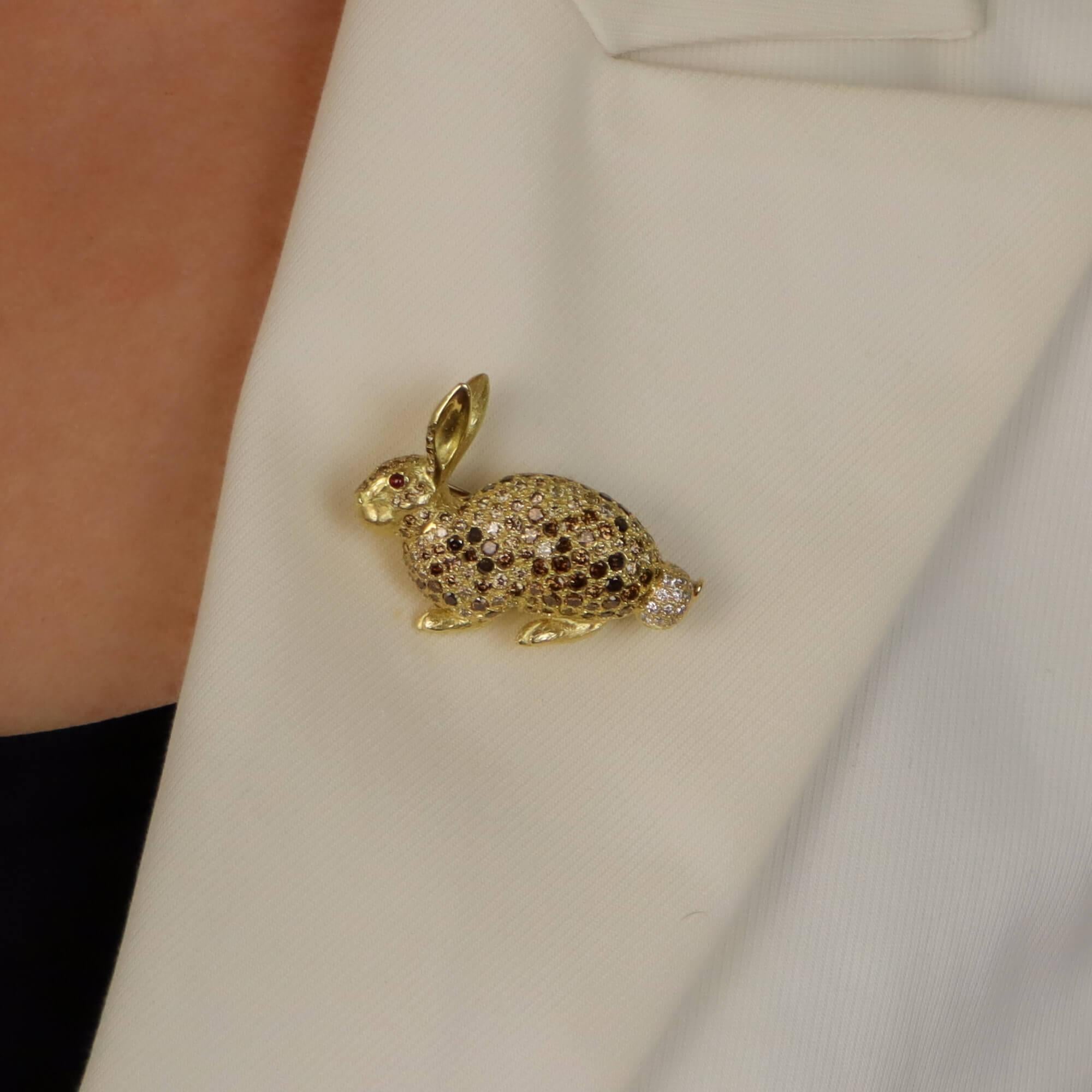 A beautiful cognac diamond and ruby rabbit pin brooch set in 18k yellow gold.

The brooch depicts a sitting rabbit and is pavé set throughout with various shades of round brilliant cut cognac diamonds. Although completely set with stones, the maker