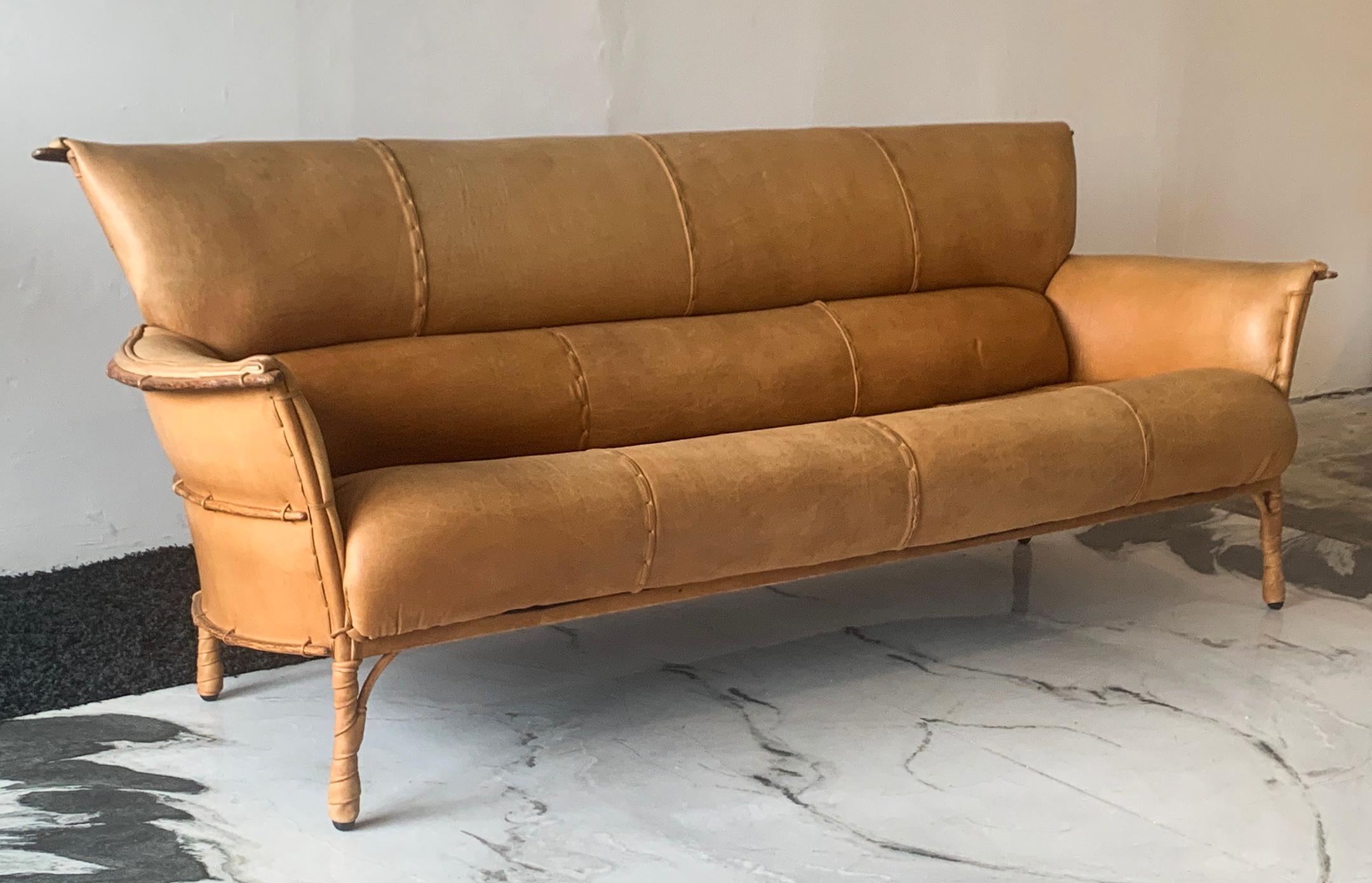 One look at this sofa and it's obvious that it's special. Designed by Pacific Green Furniture, this cognac leather clad sofa features palm wood ribs / boning throughout the frame and back that echo the canoe building techniques by Indigenous and