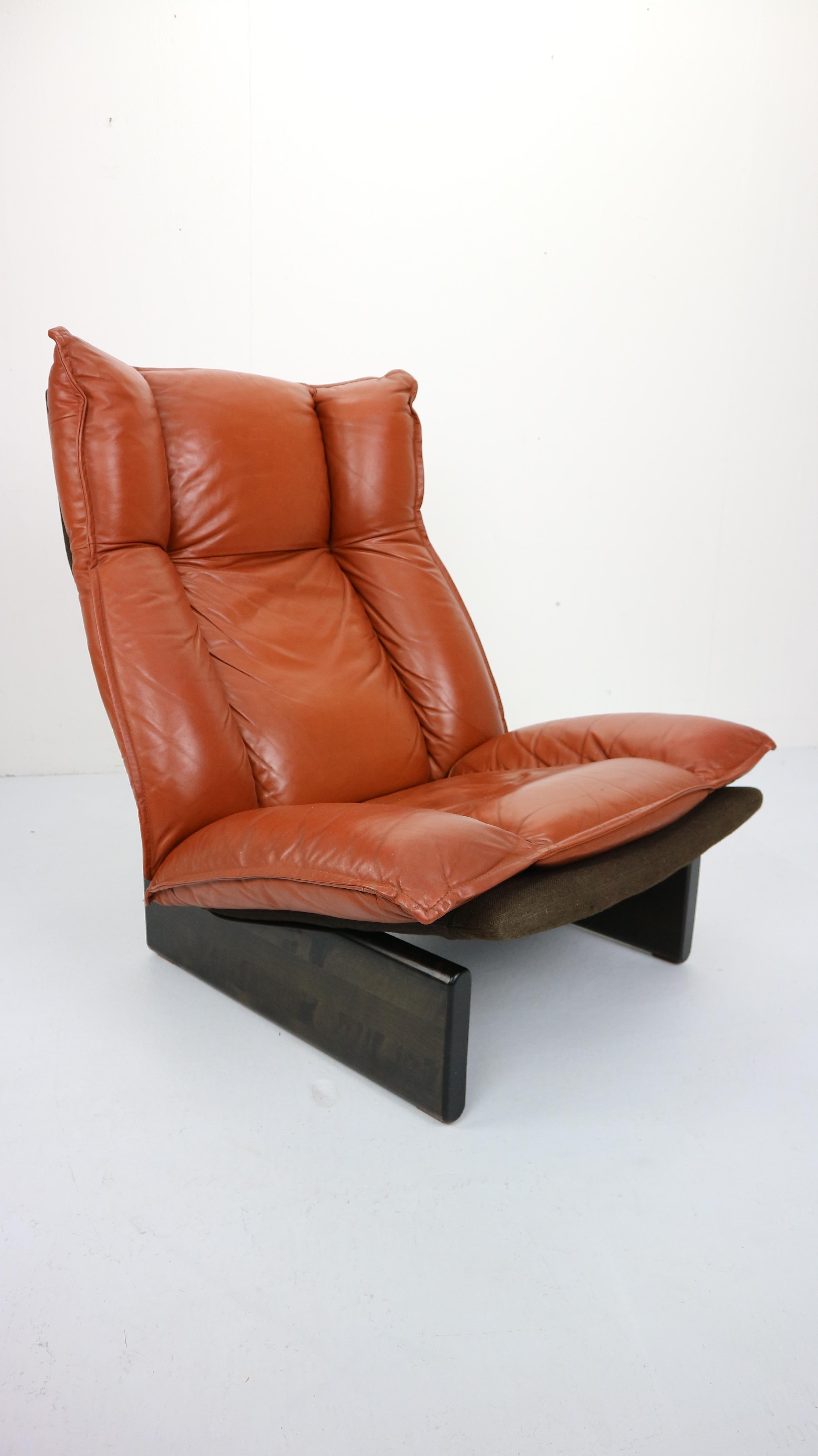 Cognac super comfortable lounge chair is an eyecatcher for your home.
Dutch modern design, 1970s.
The seating and back are made of one piece, upholstered with comfortable cognac leather cushions. This piece is resting on a solid wooden base.