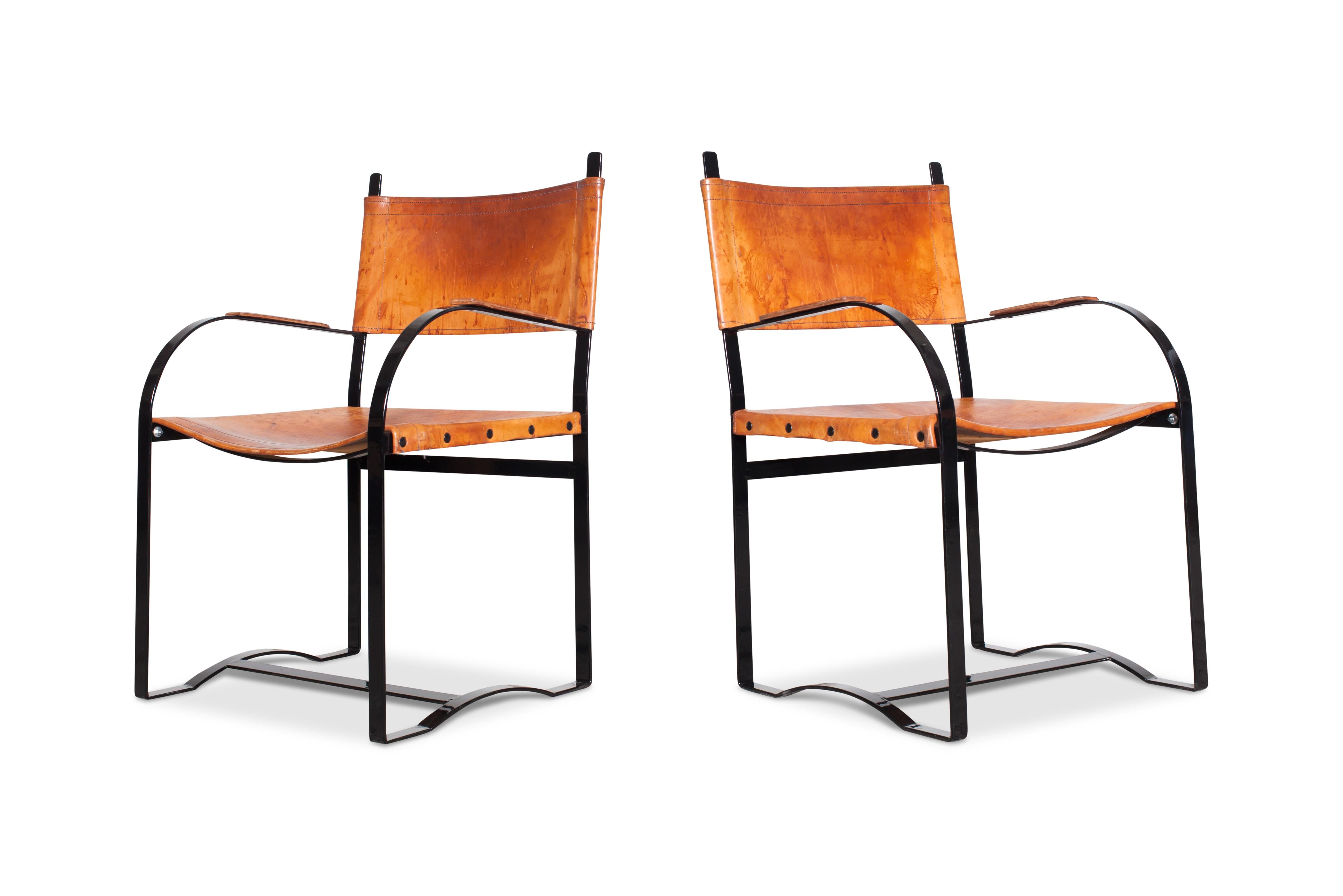 Midcentury Scandinavian Modern patinated cognac leather dining chairs. 
In the style of the Flat Steel Series by Danish designer Hans Wegner. Black lacquered steel frame and cognac leather support. The patina on these chairs is truly amazing.

We