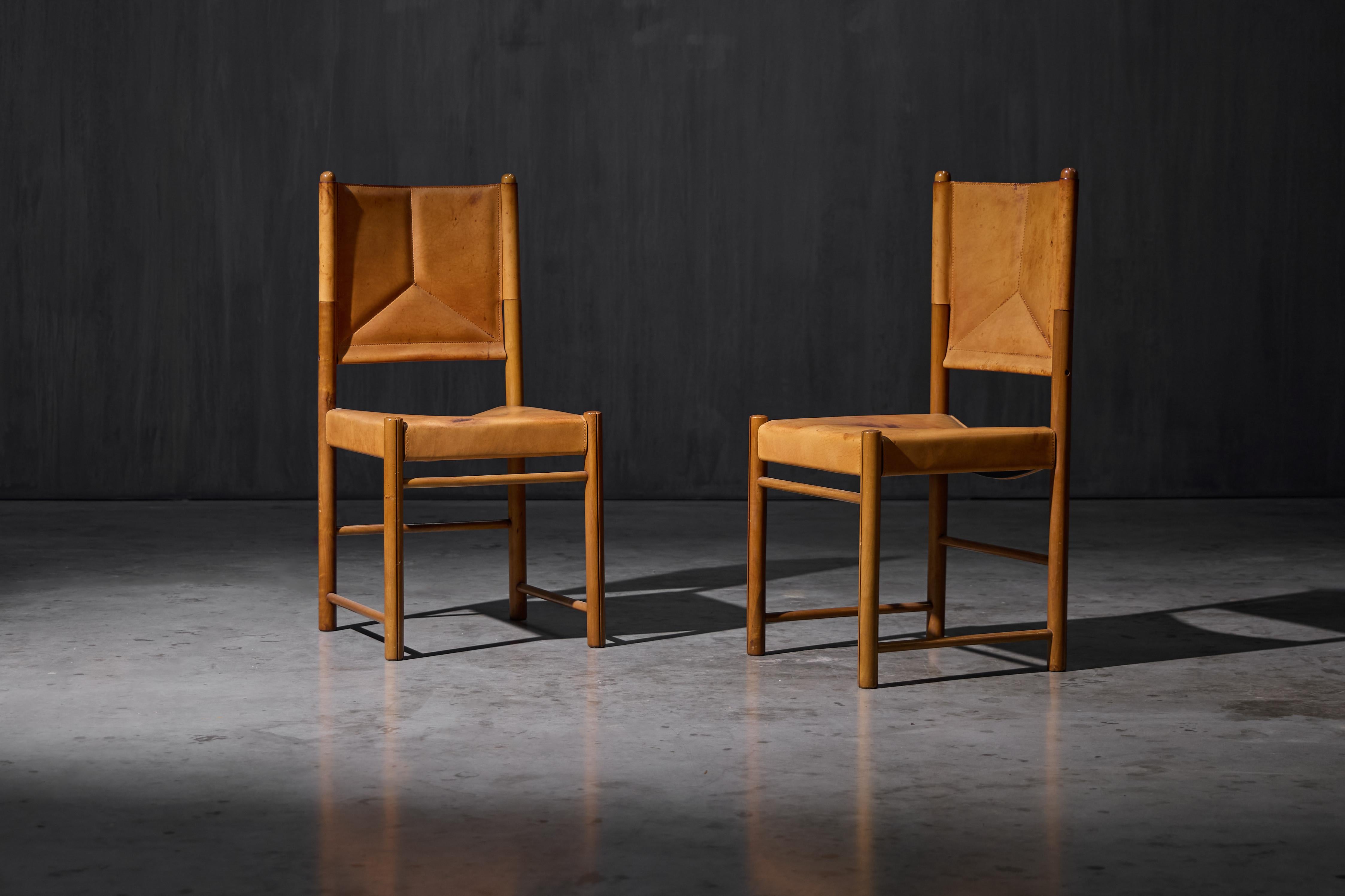 Sillas de comedor de cuero coñac, fabricadas en Italia en la década de 1960. Estas sillas presentan una tapicería de cuero natural de silla de montar bellamente patinado y se apoyan en un sólido armazón de nogal. Su construcción muestra el uso de