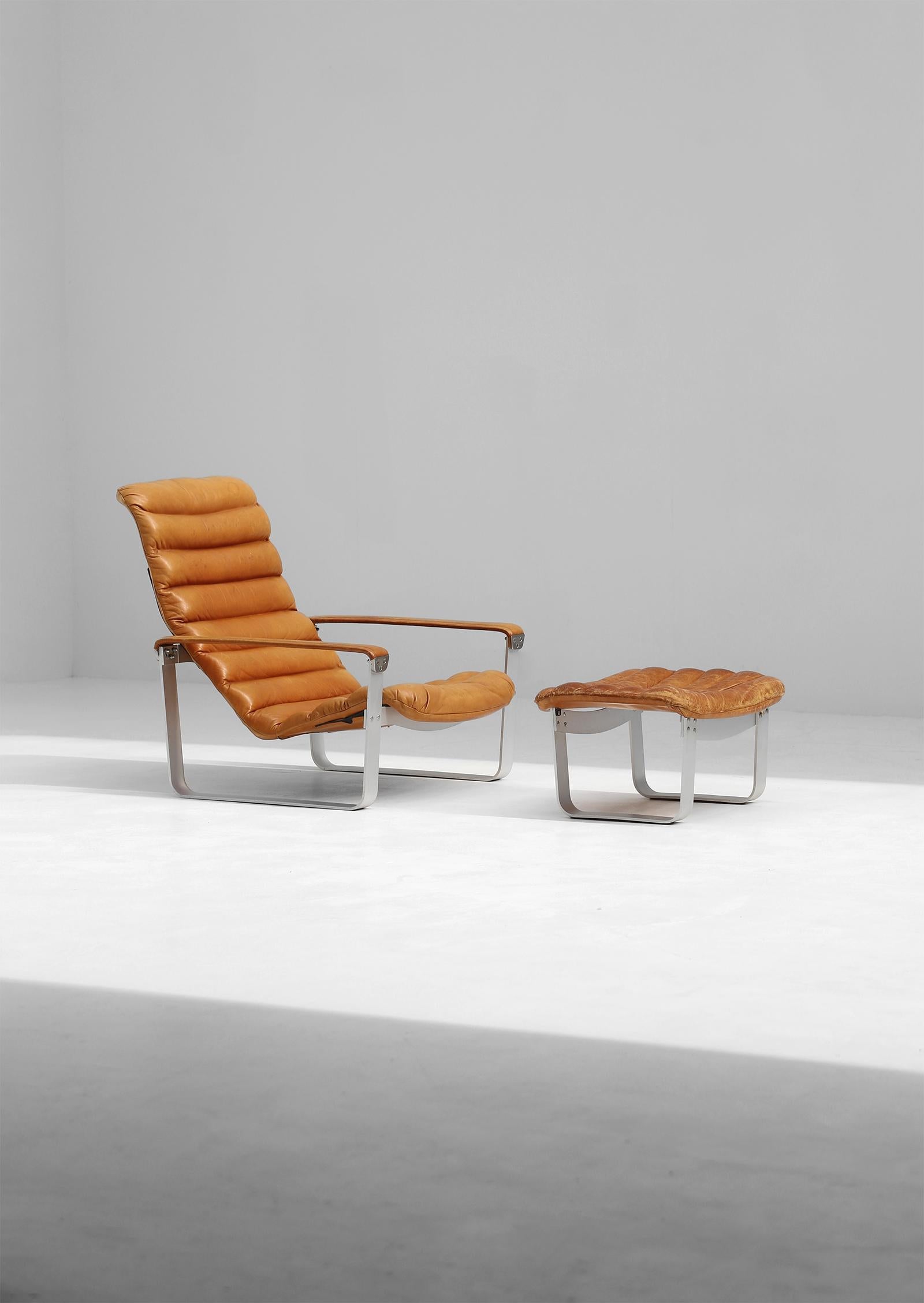 Lounge chair with Ottoman designed by Ilmari Lappalainen For Asko 1960s. Both items have an aluminum base and are upholstered in a cognac coloured leather, which has gained a beautifell patina over the years. The seating is adjustable in three