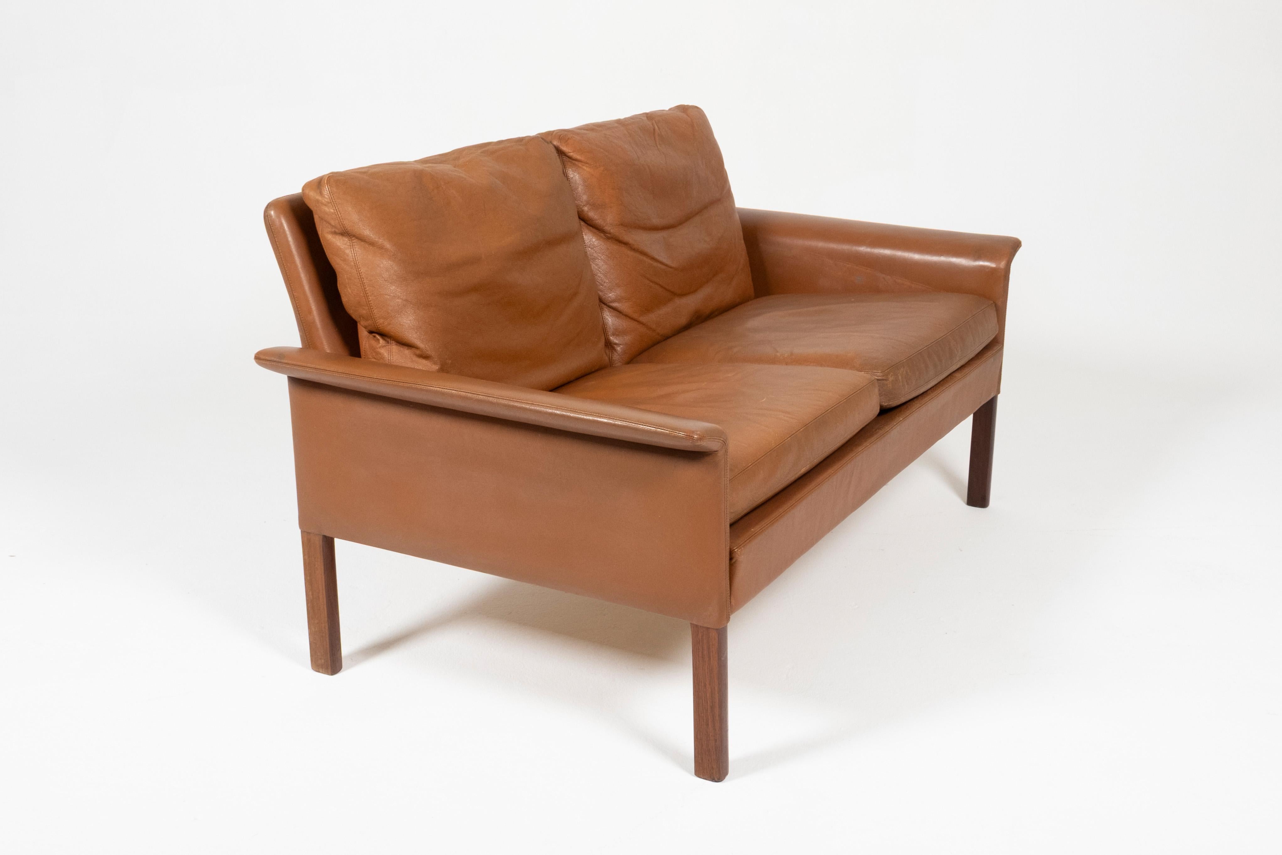 A refined mid-century Danish two-seater sofa designed by Hans Olsen for CS Møbler, Denmark, circa 1960s. The design features Olsen’s distinctively flared armrests and clean, architectural lines. Crafted from richly grained solid rosewood and
