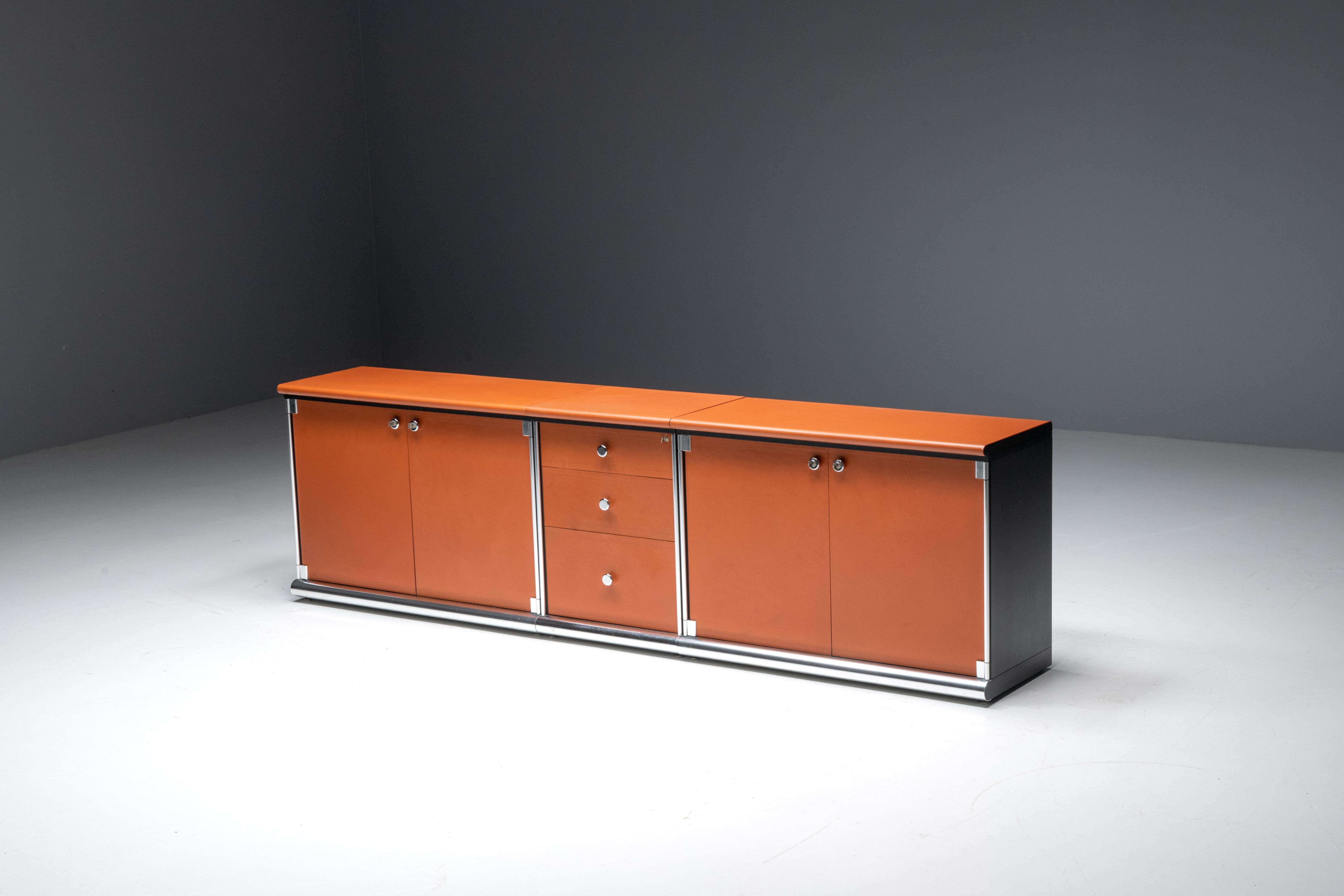 This sideboard is a captivating creation by the renowned Italian designer Guido Faleschini for I4 Mariani. Enveloped in a luscious red cognac leather, this sideboard exudes a bold and vivid aura reminiscent of the seventies. Comprising two cabinets