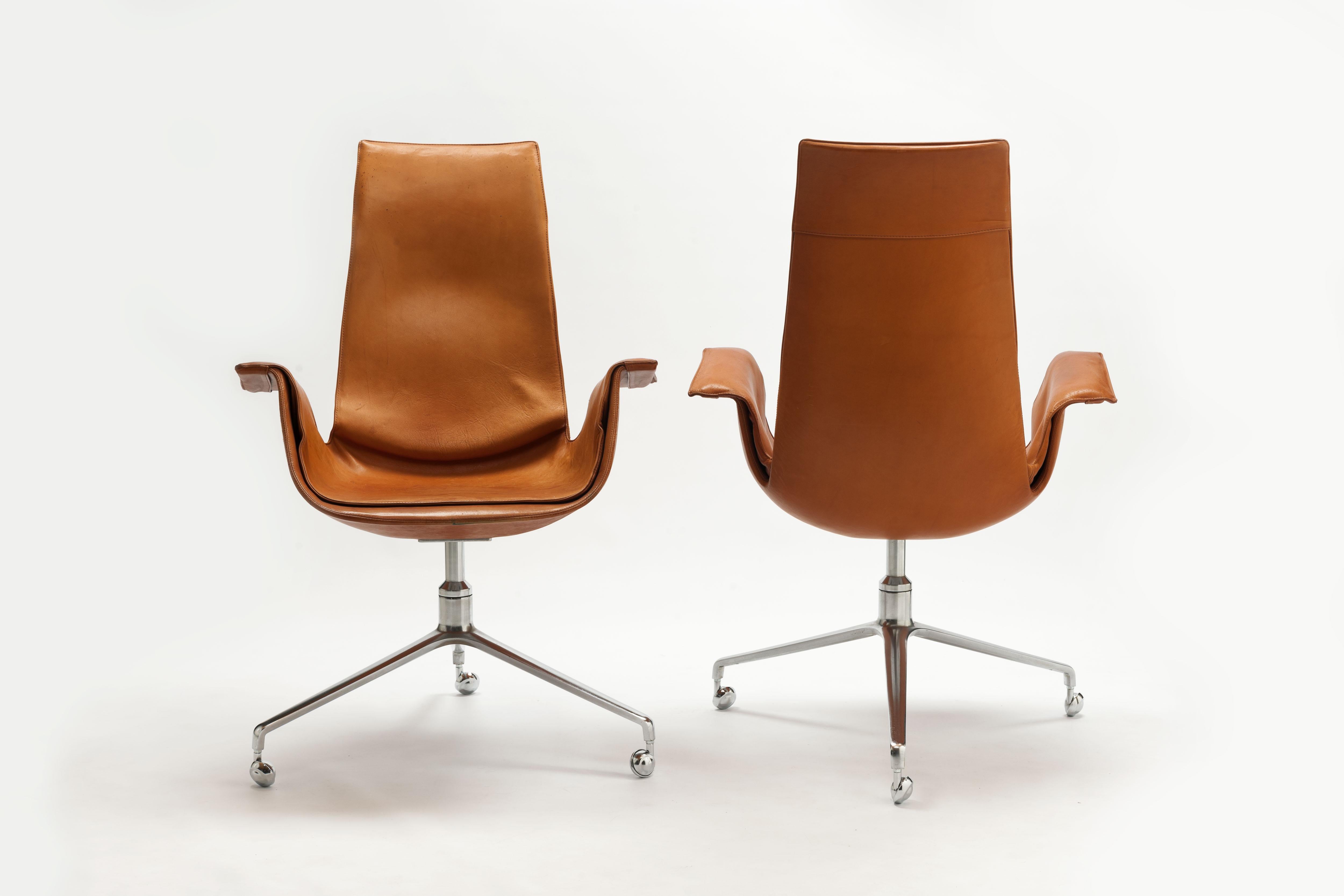 Set of two swiveling high back 'Bird' desk chairs, model FK 6725, in Cognac leather and steel, by Preben Fabricius and Jørgen Kastholm, 1966, produced by Kill International. 
This is the original 1st production series with signature polished cast