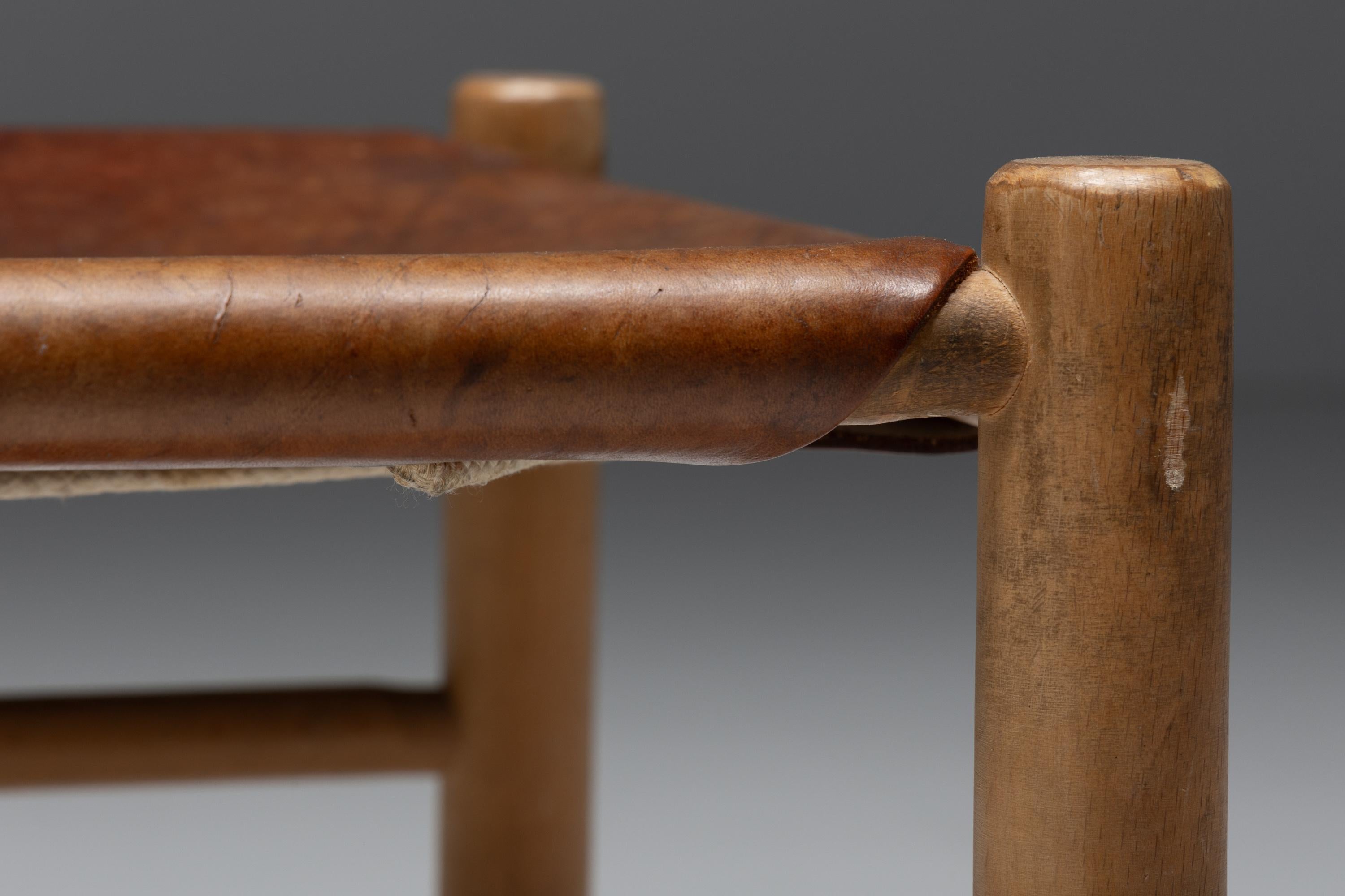 Moderner Hocker aus der Mitte des Jahrhunderts, hergestellt in Frankreich in den 1950er Jahren. Das Design zeichnet sich durch ein stabiles Gestell aus elegant geformten Holzzylindern aus, die für außergewöhnlichen Komfort sorgen. Die Sitzfläche ist