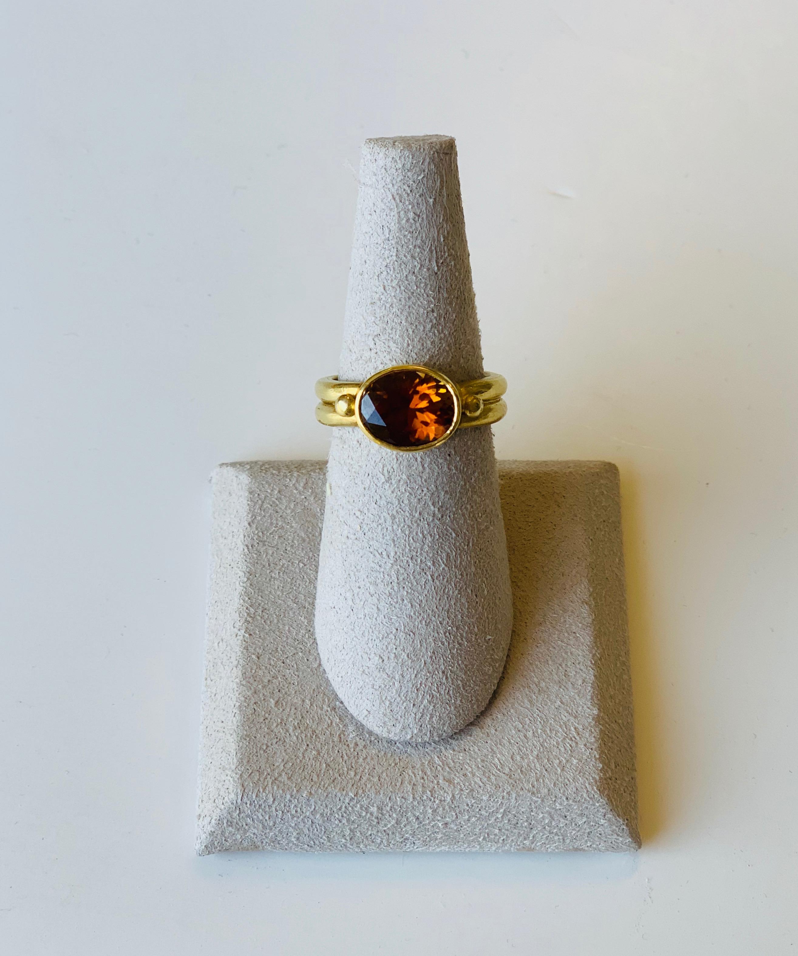 Beautiful oval Faceted cognac Tourmaline ring set in a a sturdy 22 Karat band with 2 side granules. 
Tourmaline is one of the earth's most colorful gemstones and this particular cognac color is rather rare. 
Tourmaline orange crystals convey the