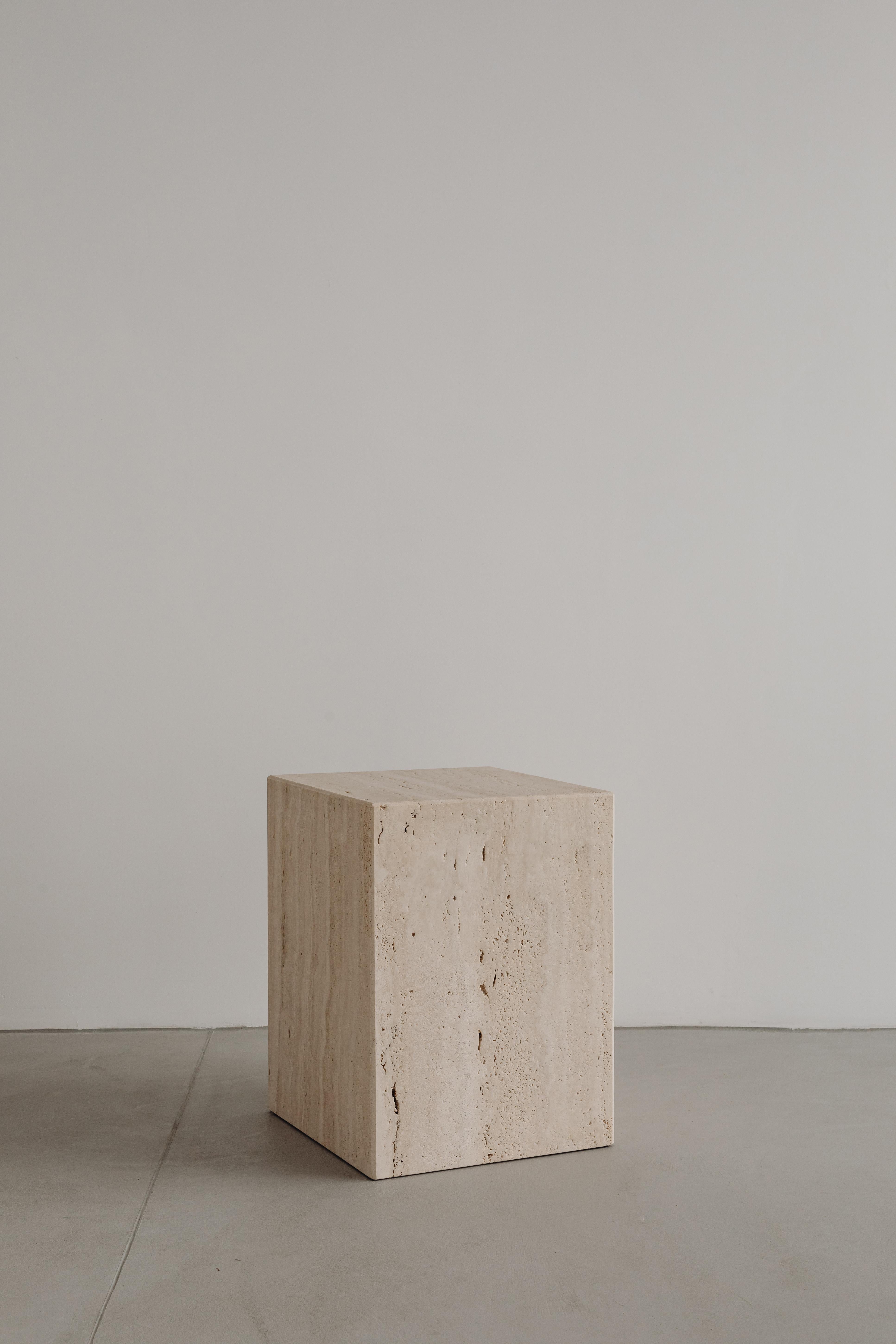 Coi Travertine Pillar by Un’common
Designed by Małgorzata Korycka.
Dimensions: D 32 x W 32 x H 42 cm.
Materials: Travertine.

COI is a minimalist and elegant piece of furniture with many functions. It can be a bedside table, side table, or seat. You