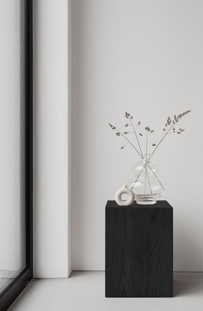 Pilar de madera Coi de Un'common
Diseñado por Małgorzata Korycka.
Dimensiones: P 32 x An 32 x Al 42 cm.
Materiales: Roble profundo.

COI es un mueble minimalista y elegante con múltiples funciones. Puede ser una mesilla de noche, una mesa auxiliar o