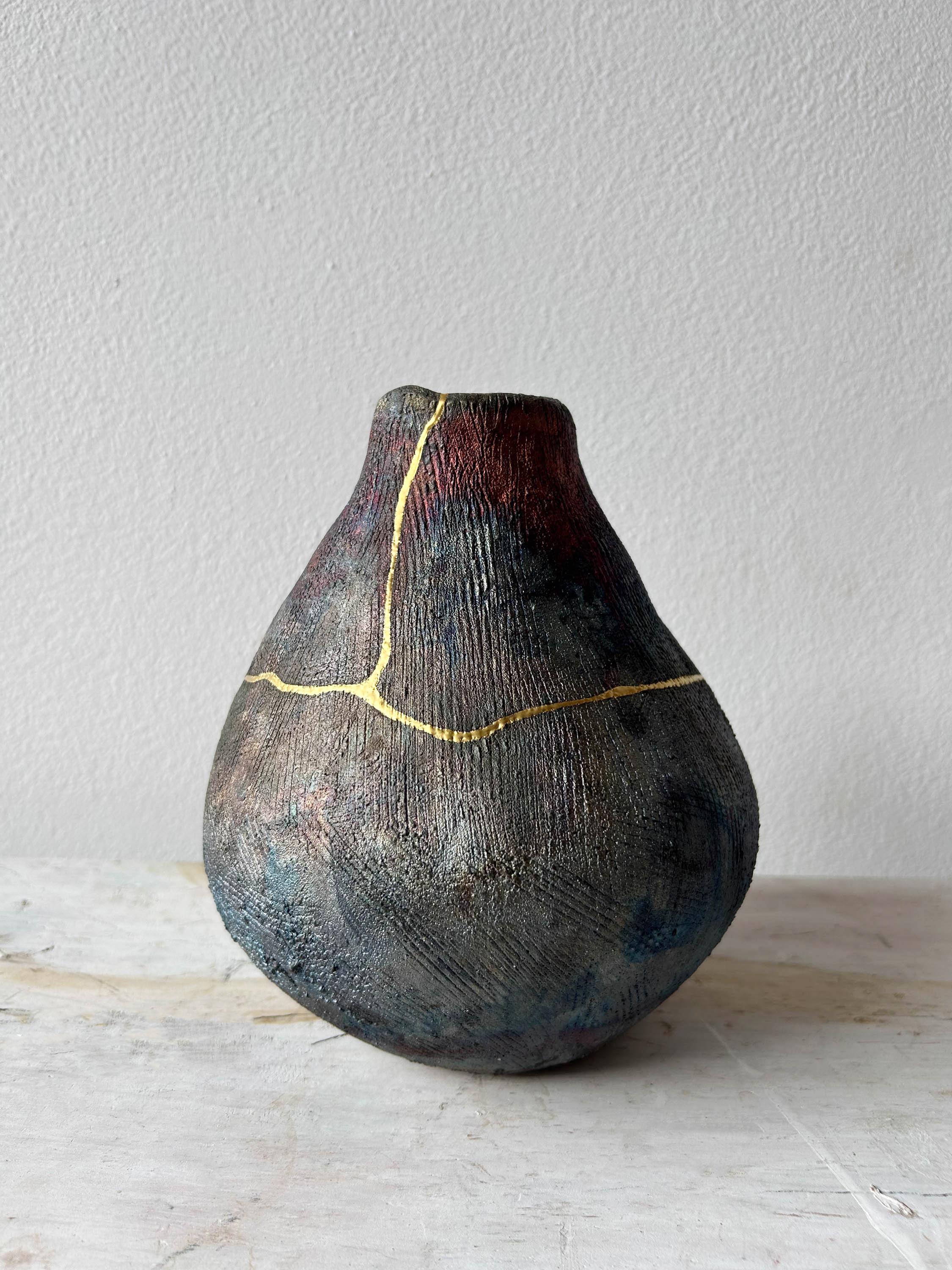 One of a kind gourd-shaped vase hand-built from coils in our Brooklyn studio then Raku fired in a New Jersey backyard. Cracked during firing, then repaired with 24 karat gold.

Approximately 8 inches heigh.  

Dried flowers only—will not hold water.