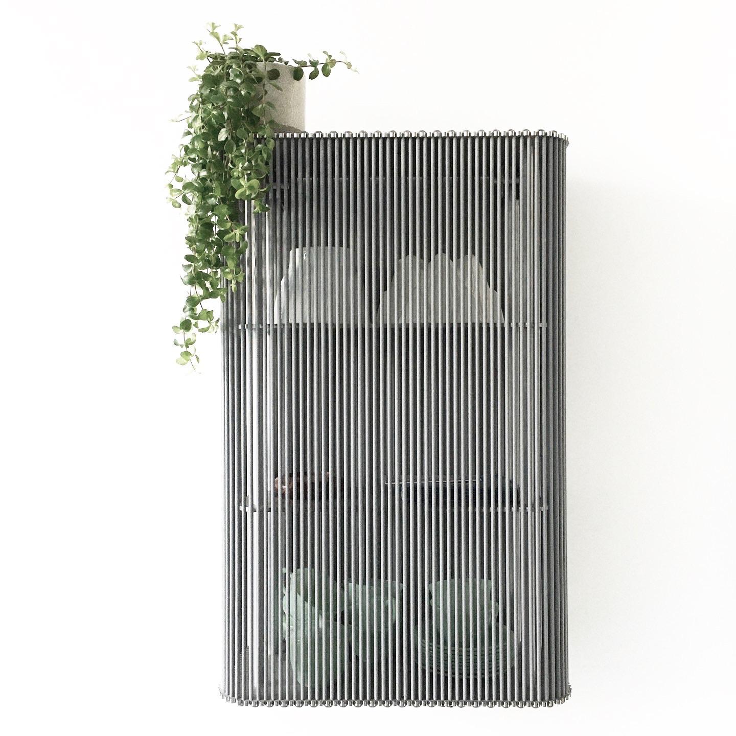 Coil cabinet wall mounted by Bram Kerkhofs
Dimensions: D50 x W25 x H75cm
Materials:Stainless steel, aluminium, elastic rope (natural rubber, polyethylene).

Other dimensions are available.

COIL is a modular cabinet system in which the ‘shell’