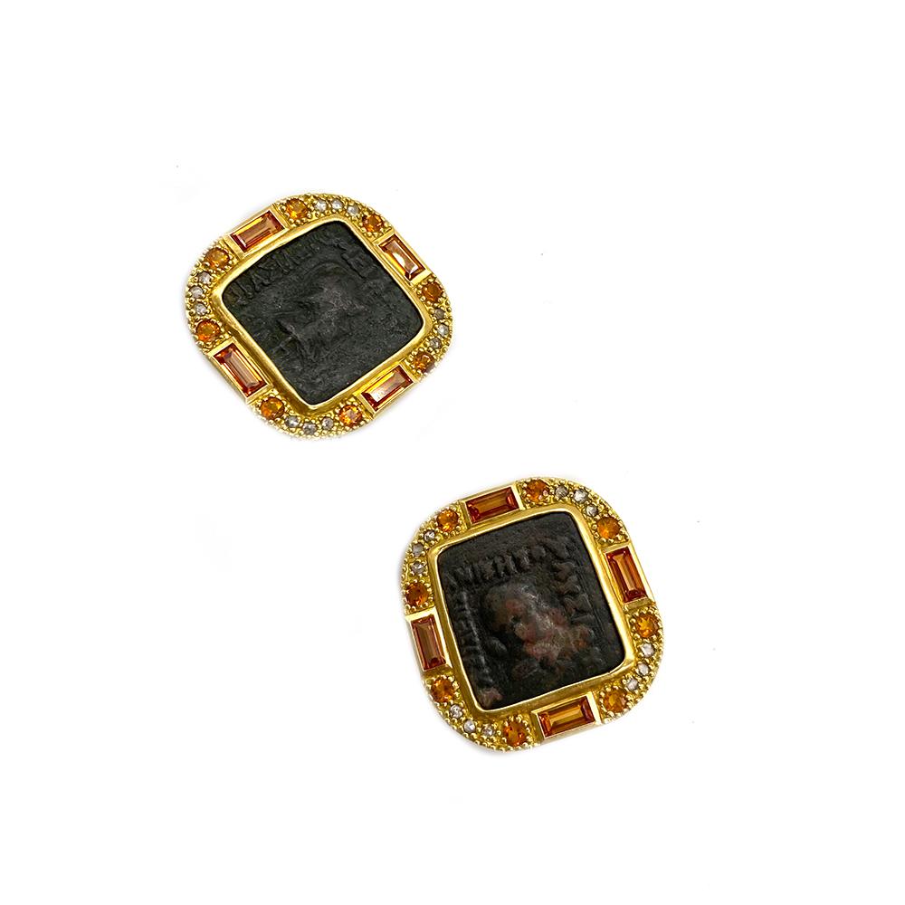 Antiquity Stud Earrings Set In 20 Karat Yellow Gold With An Indo-Greek Bronze Coin. The Earrings Are Complete With 0.50cts Diamond, 3.20cts Orange Sapphire, and 1.05cts Citrine. 
