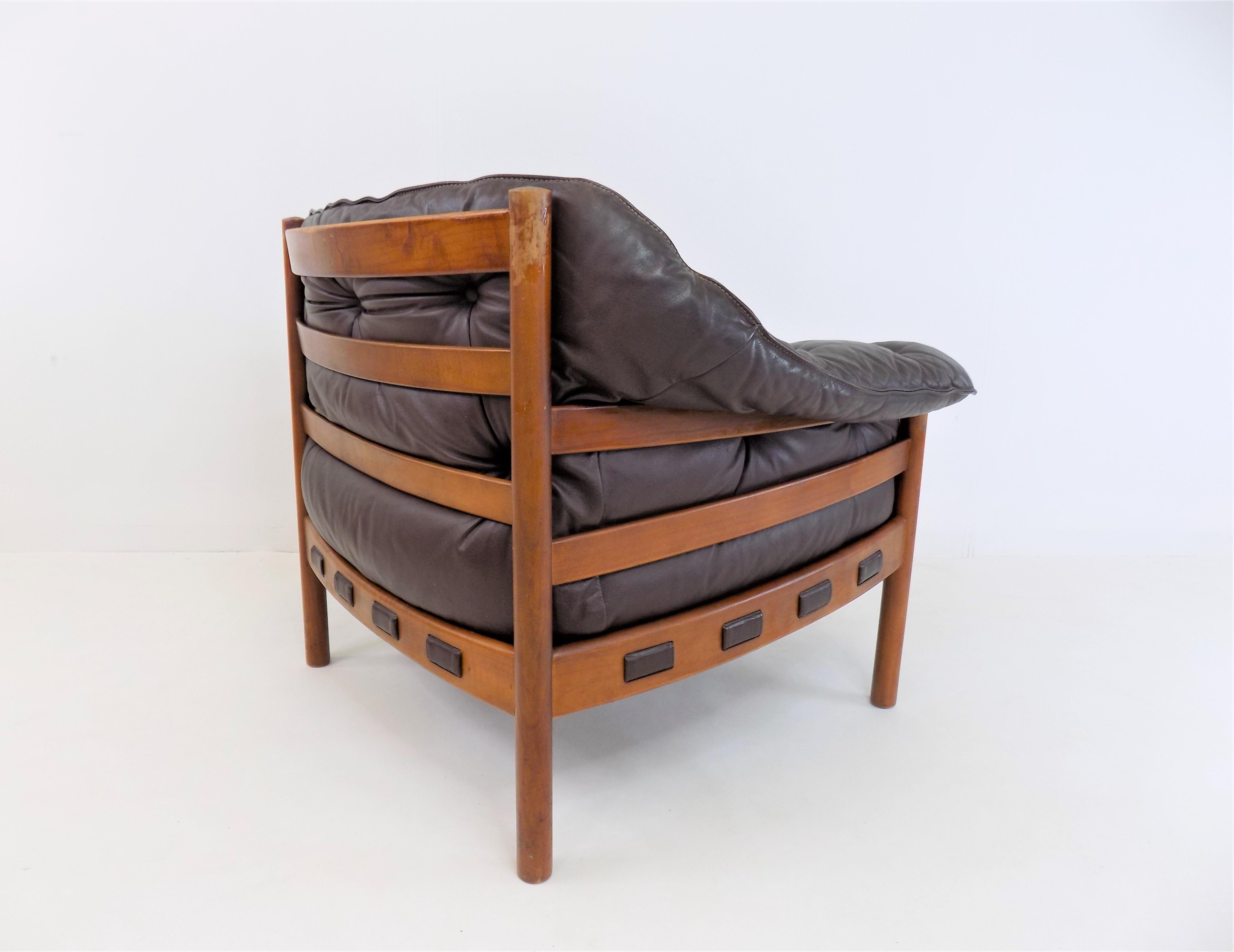 The easy chair from the 1960s, designed by Sven Ellekaer for Coja, is in very good condition. The chocolate brown leather is flawless and soft with no major signs of wear. The wooden frame shows slight signs of wear on the corner posts. The