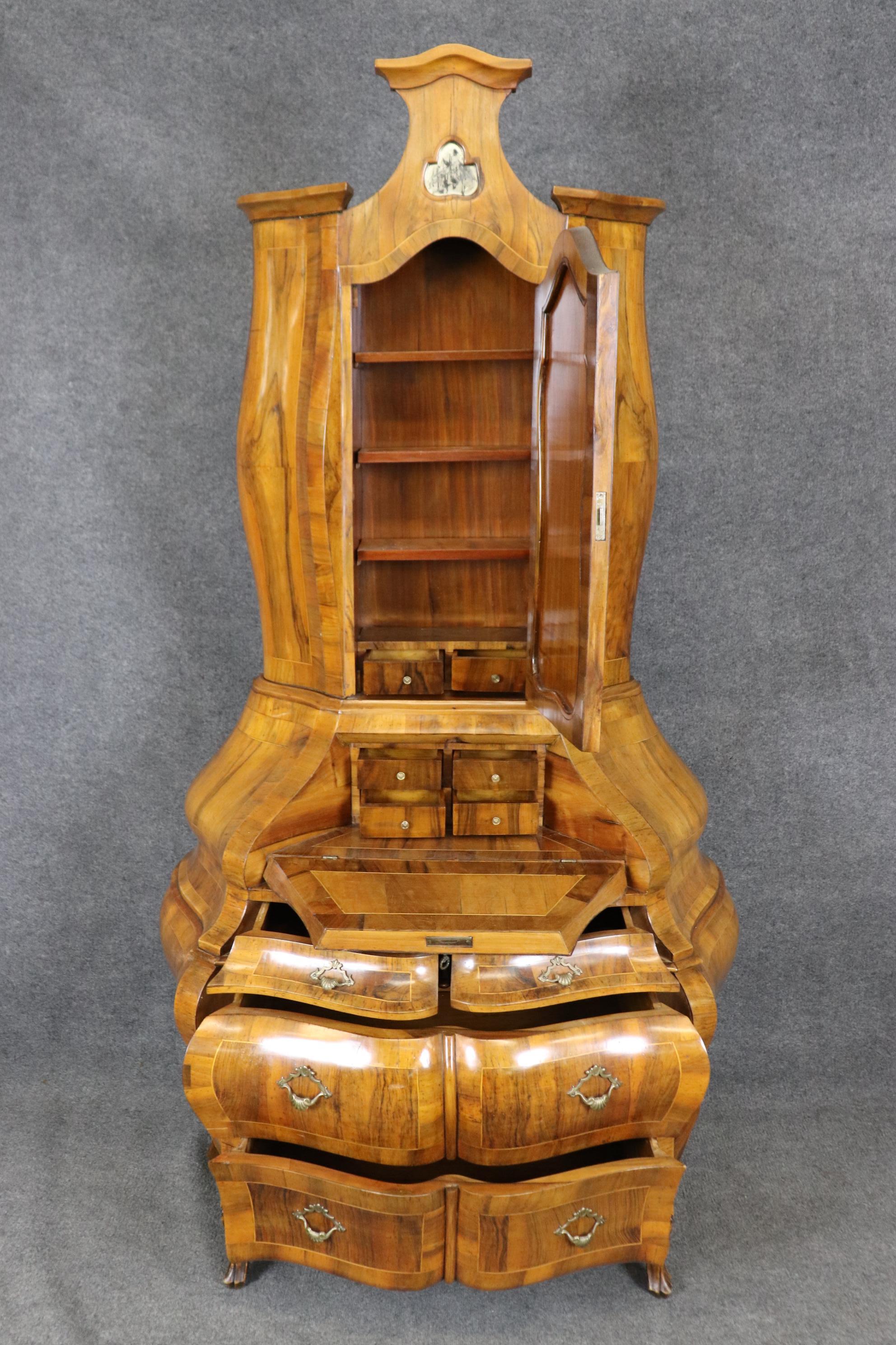 This is a drop-dead gorgeous olivewood Italian Rococo Florentine style secretary desk. The desk has that very sought after coke-bottle form and beautiful patina to finish of the case and the mirror as well. The desk opens up to reveal small cubbies