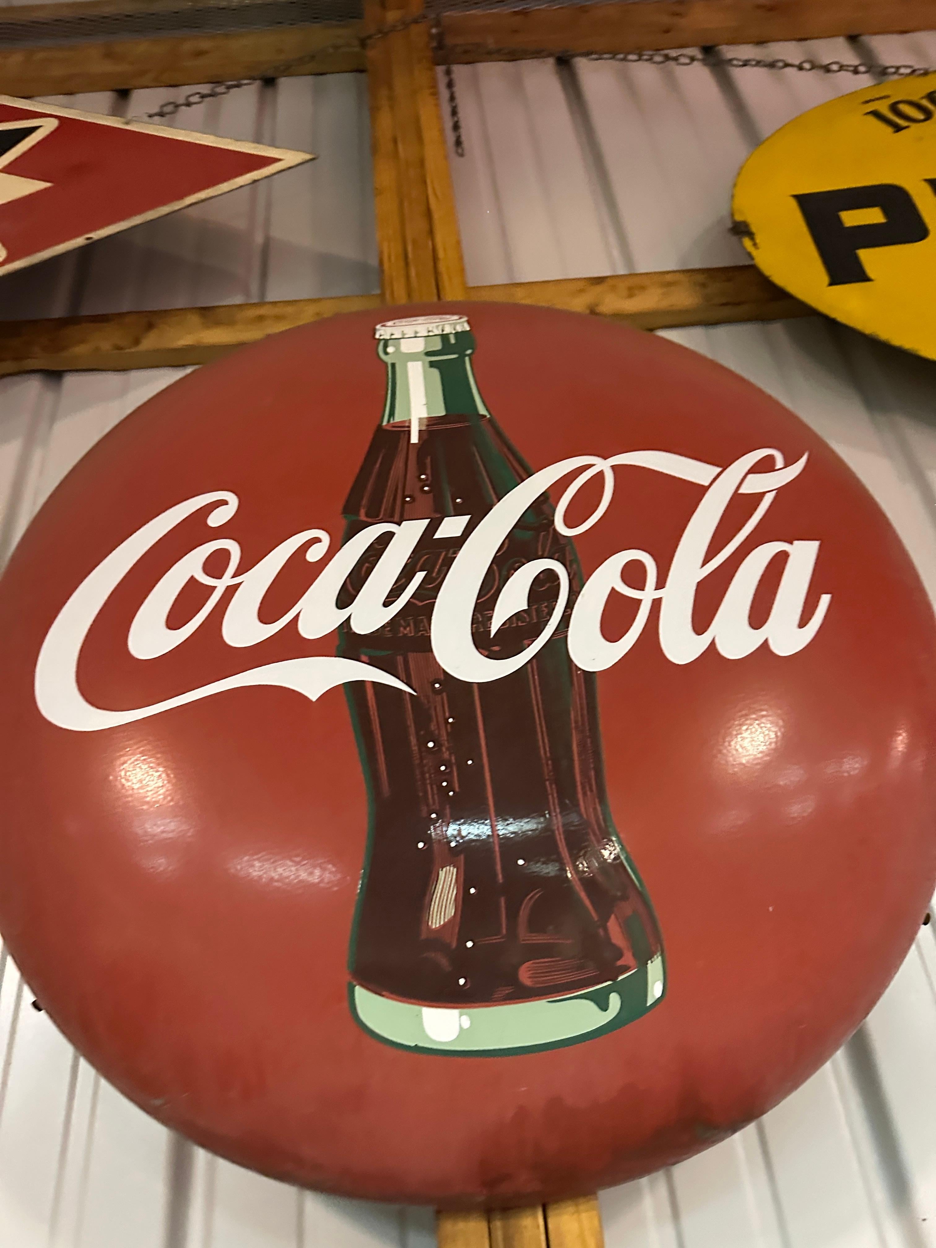 Il s'agit d'une pancarte émaillée vintage de Coca Cola. L'ensemble est en bon état, avec une légère usure sur les bords et de légères salissures en surface. Pour le reste, ce signe se présente bien. 