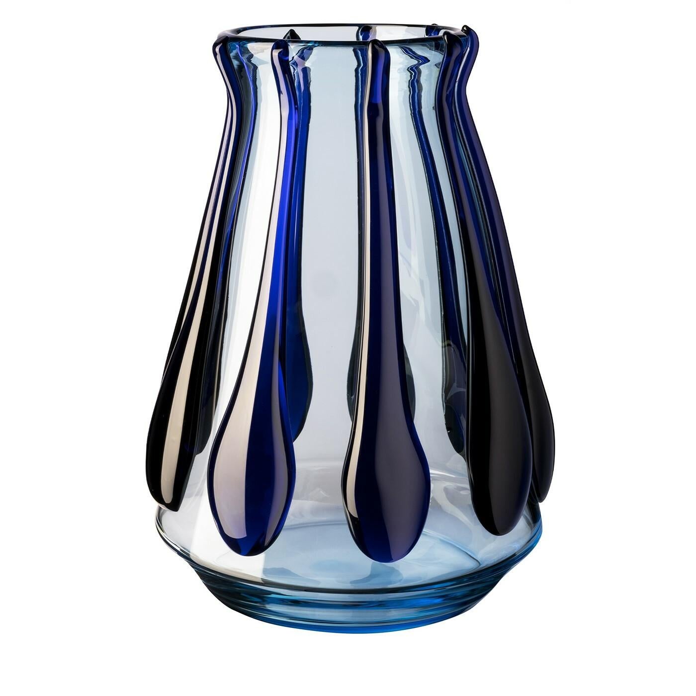 This singular vase is an exquisitely modern reinterpretation of the iconic Colate Vase by Carlo Moretti. Marked by a flared shape slightly tapering towards the mouth, it is achieved by masterfully blowing azure Murano glass and consequently applying