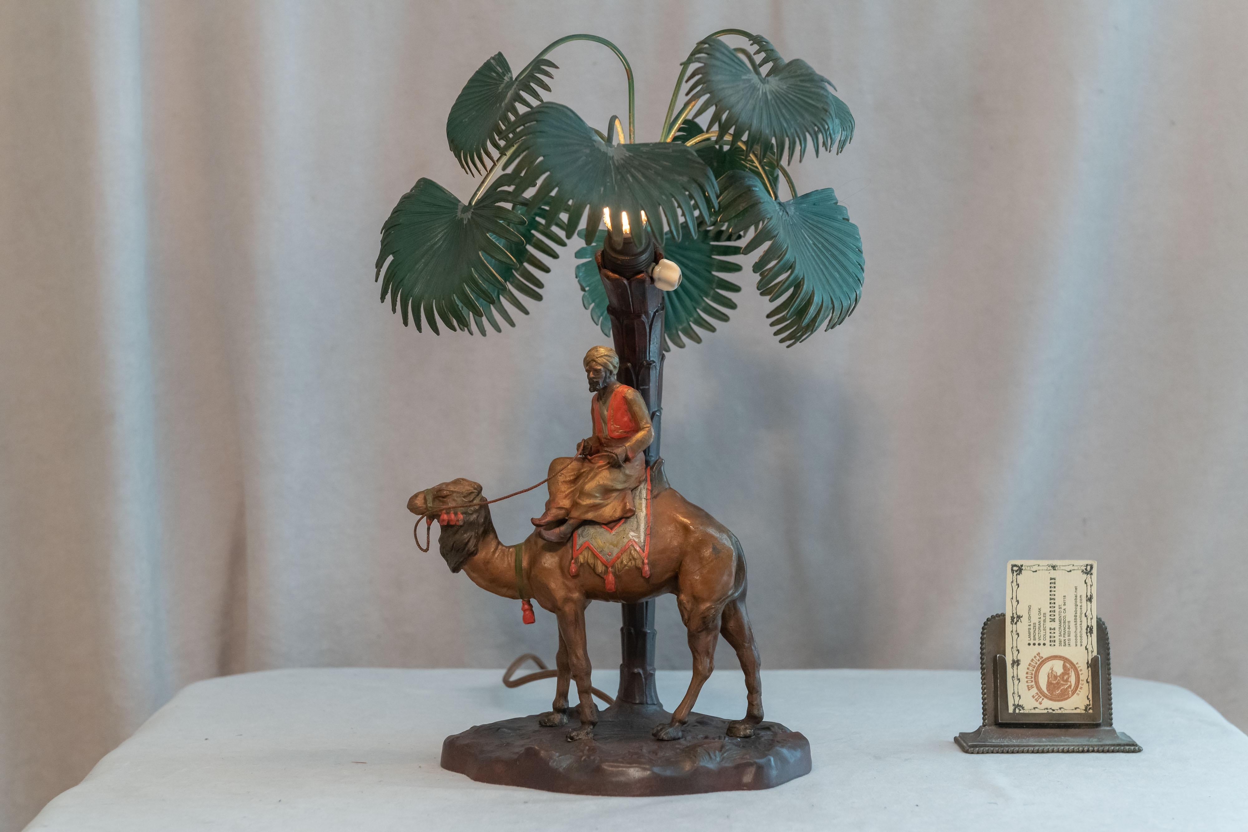 This cold painted Orientalist theme lamp is very colorful and well modeled. The rider and his camel sit under a palm tree. Amazingly all the palm leaves are all there and still intact. The metal used here is generally called spelter. It is also
