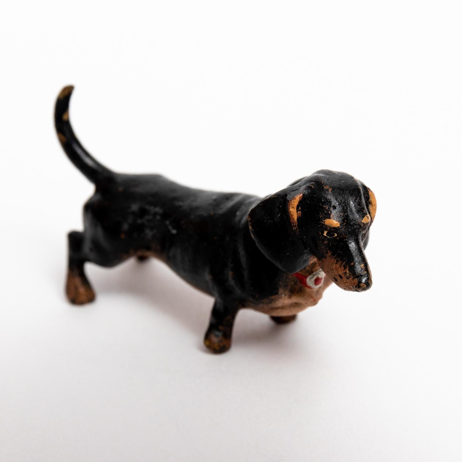 Circa 20th century cold painted bronze Dachshund in black and brown accented with a red collar. Made in Austria. Please note of wear consistent with age.