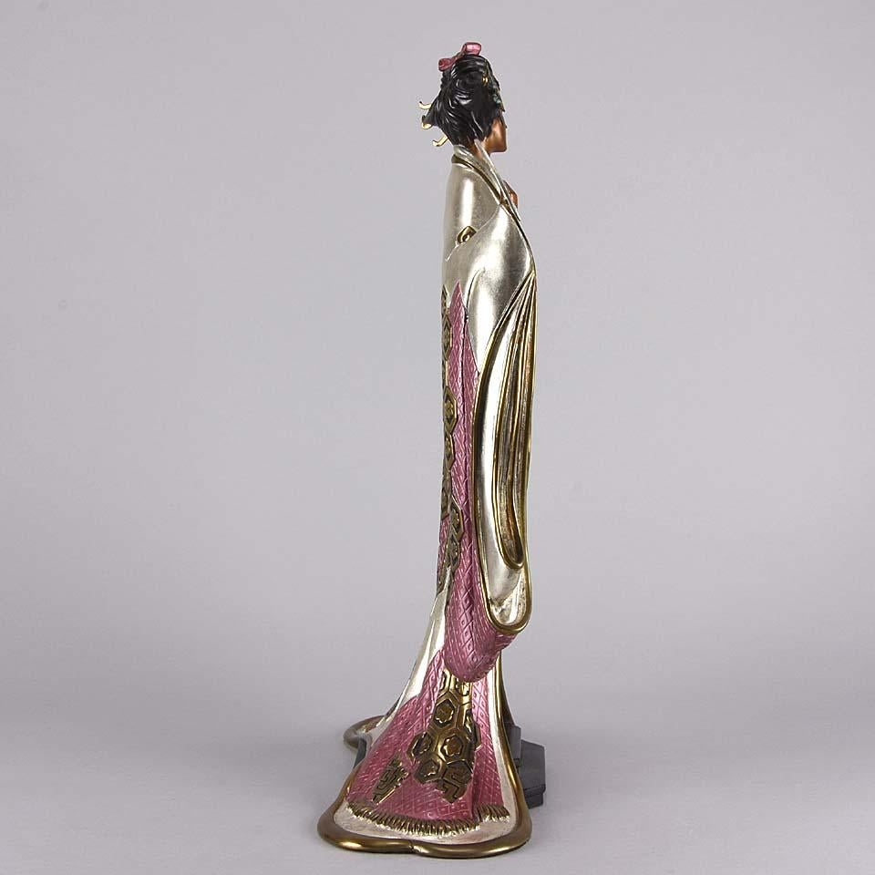 A fabulous limited edition Art Deco bronze figure of an Oriental beauty wearing a glamorous full length dress cold painted with variegated pink, silver and gold, finished with very Fine surface detail. Signed Erté, dated 1989, numbered 166/500 and
