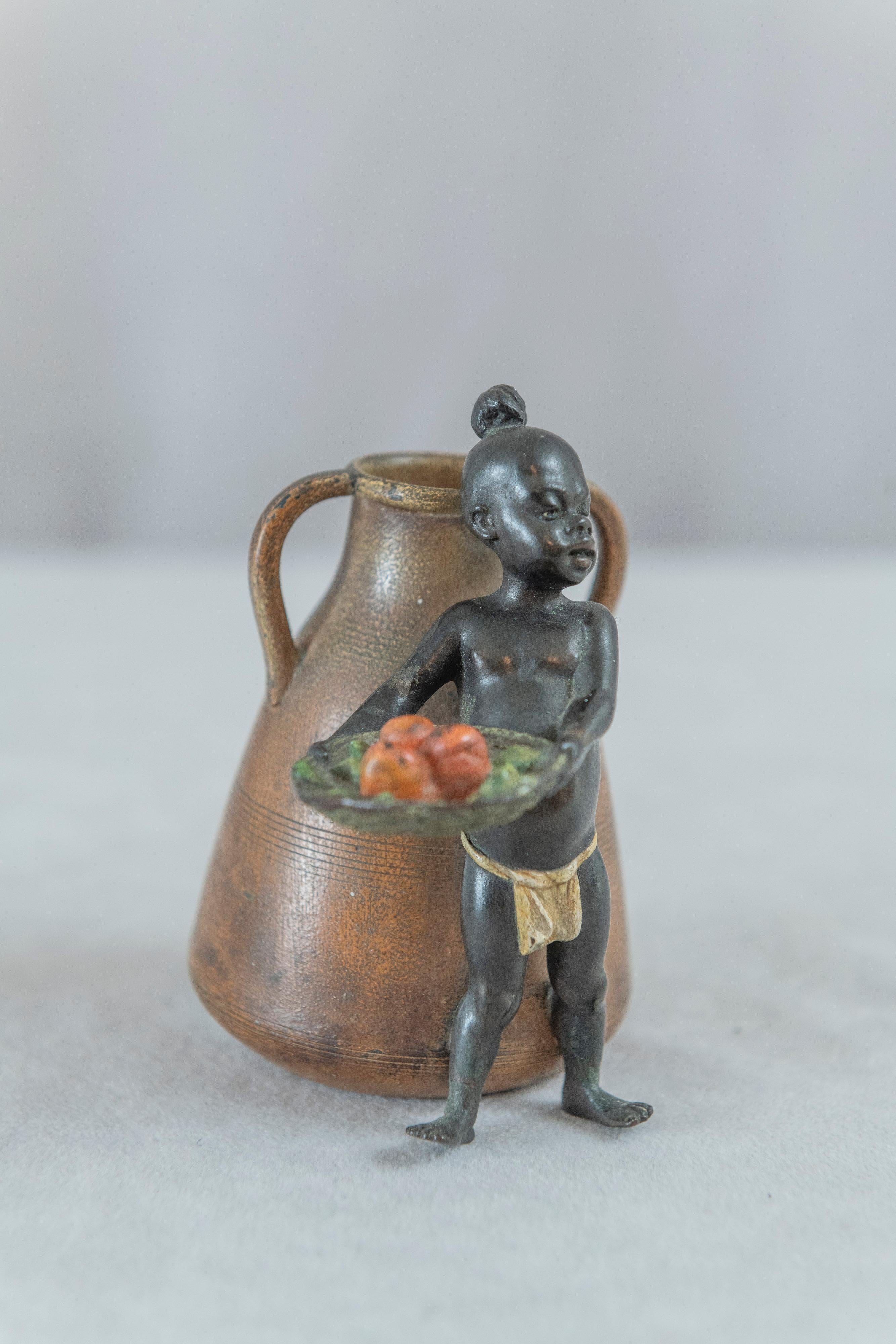  This highly detailed cold painted bronze was meticulously executed by the premier maker of Vienna bronzes, Franz Bergmann. The foundry signature is boldly impressed under the boy's basket. The young boy stands proudly with his basket of fruit that