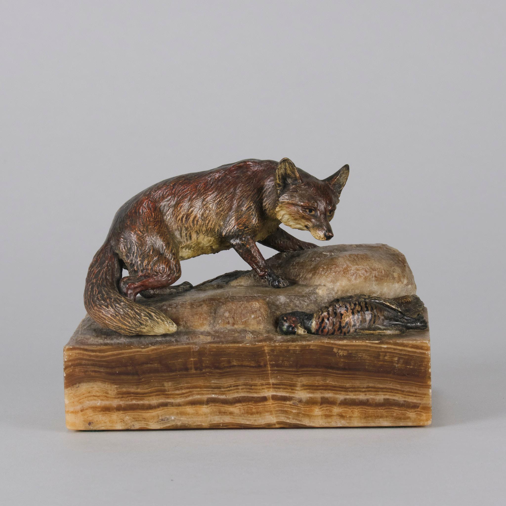 Very fine cold painted Austrian Bronze study of an alert fox standing upon higher ground checking its surroundings with its prey beside a rock. The bronze with excellent cold painted colours and very fine hand chased surface detail, raised on a