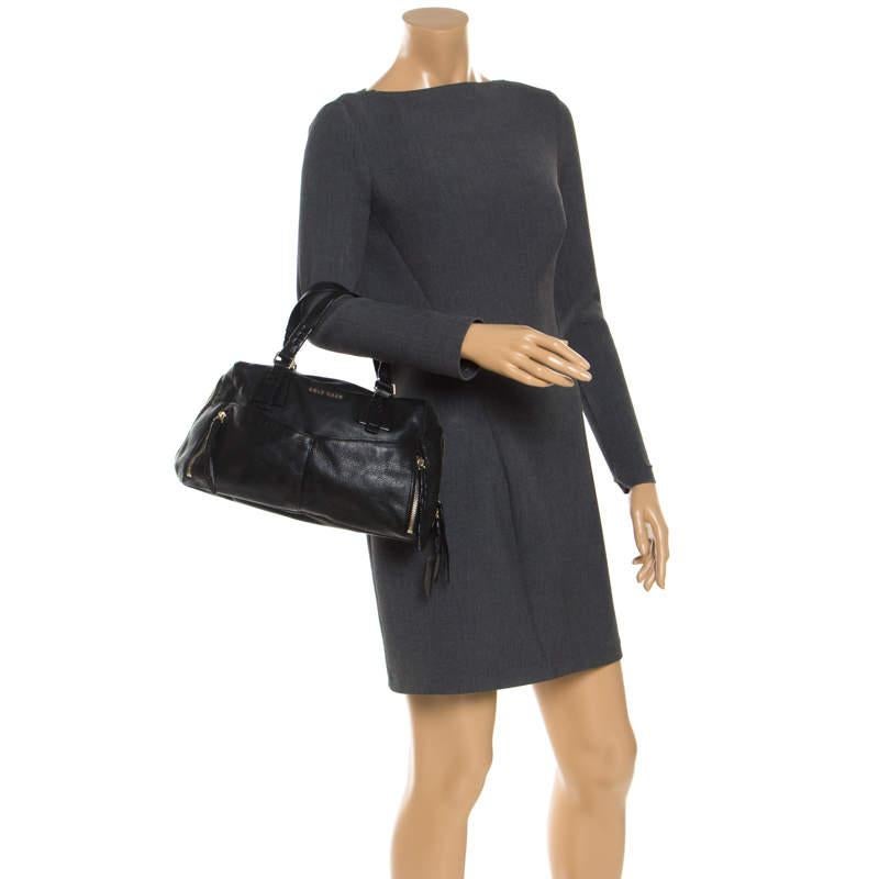 Make heads turn with this leather satchel by Cole Haan. It comes in black color and features a sophisticated design. It is equipped with dual handles, external pockets, zip closure, and gold-tone hardware. The interior is lined with fabric and is