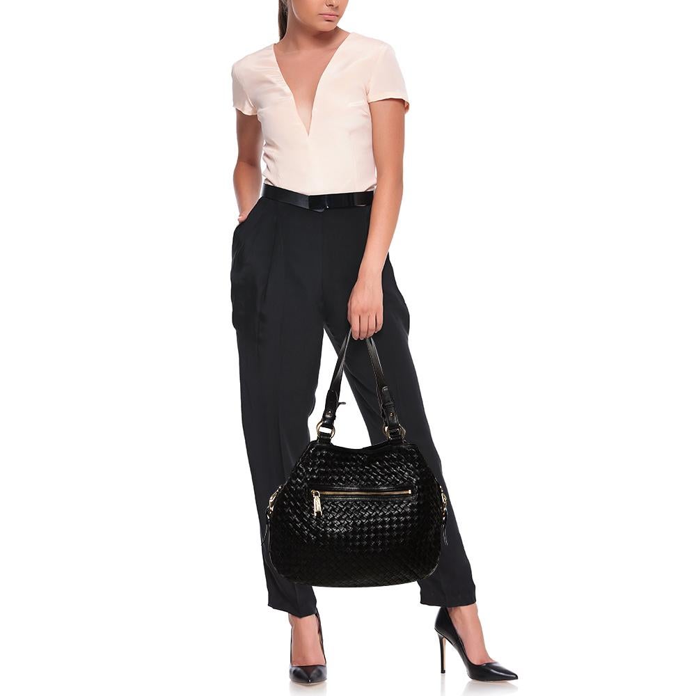 Add some magic to your everyday attire with this super stylish and classy tote from Cole Haan. Crafted from black leather, it features a woven design on the exterior and comes equipped with dual top handles. It flaunts a zip pocket on the front and