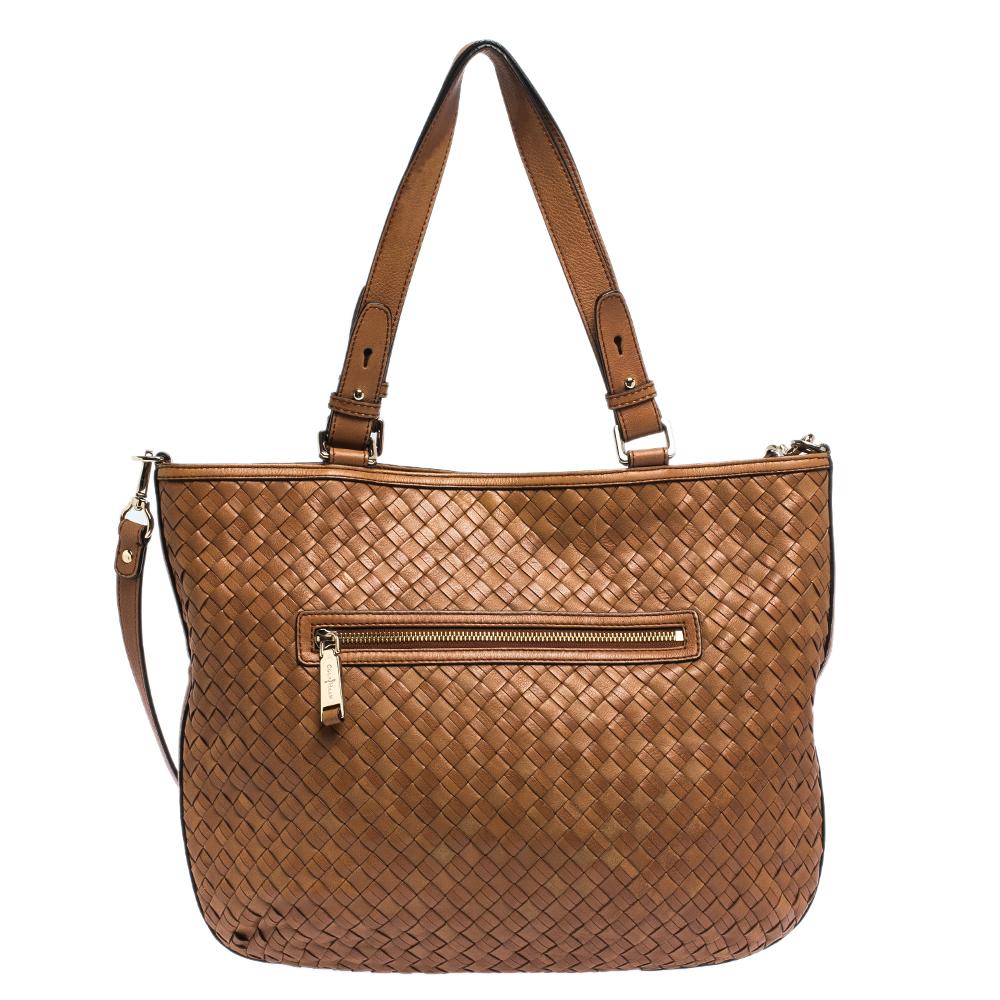 This fashionable tote by Cole Haan is all you need to perfectly complement your attire. Woven expertly using leather, this bag can effortlessly be fashioned with both off-duty and formal looks. The interior of this gorgeous bag is lined with satin