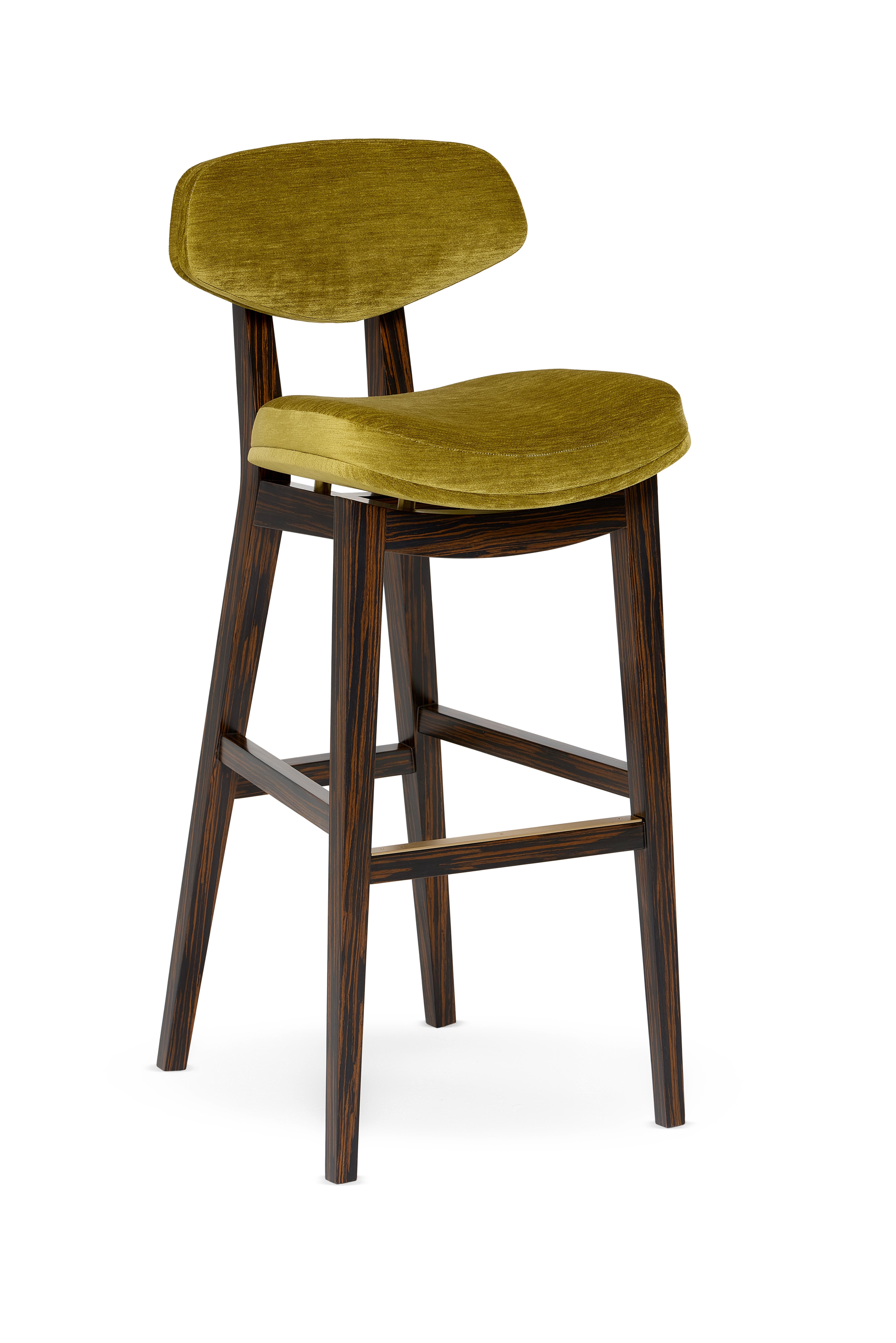 Coleman Bar Stool by Munna
Dimensions: D 54 x W 44 x H 105 cm. SH: 80 cm.
Materials: Solid wood, foam, brass, and upholstery.
Finish: Upholstery: Vivid Chenille, ref. Moss, VIC13. Legs: Ebony wood veneer is finished with Matt varnish. Metal Details: