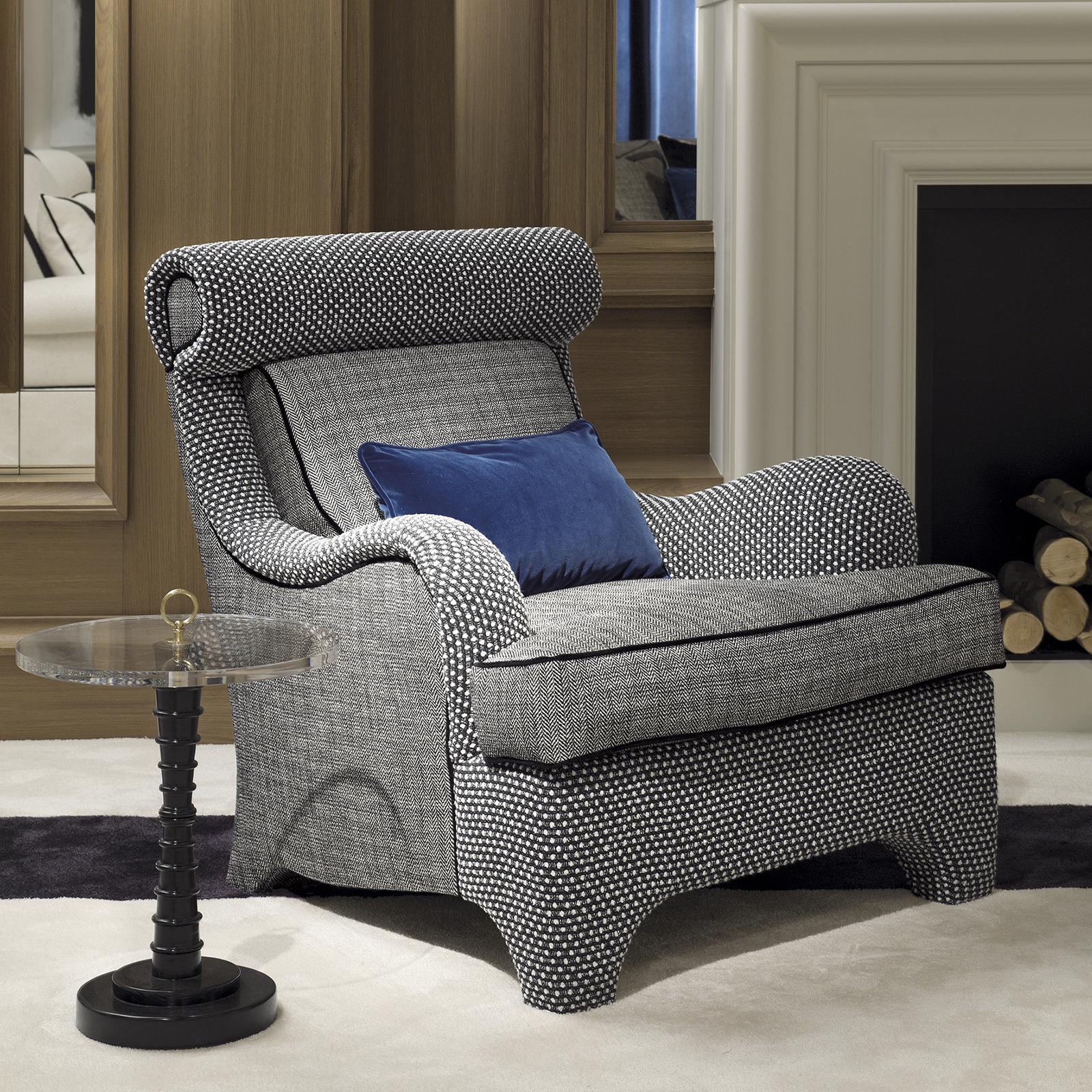 A harmonious combination of refined design and cozy volumes, this armchair is a unique addition to a living room or study. Its sinuous silhouette in solid wood is covered with a plush seat with curved armrests and a back reclined to guarantee