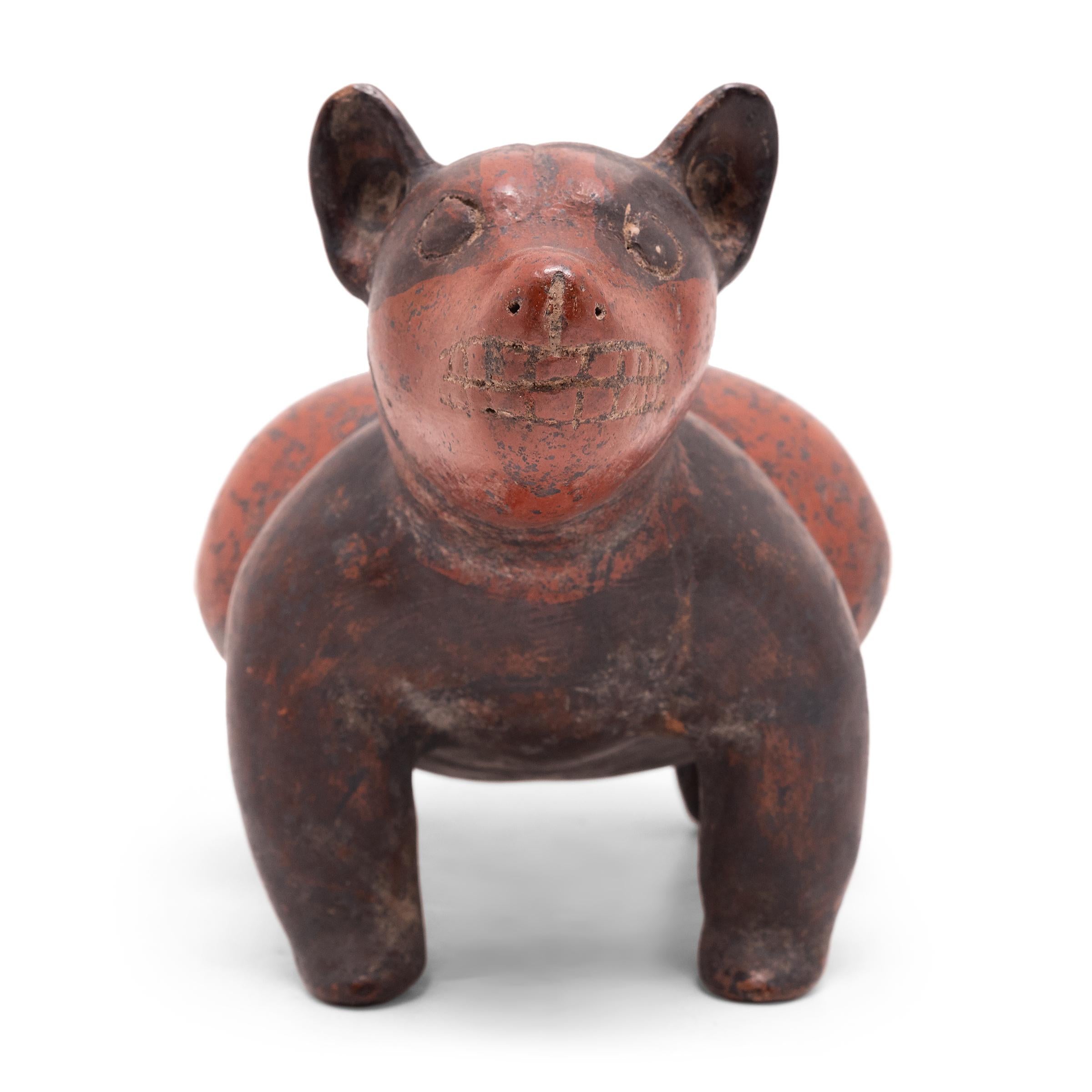 This charming ceramic dog is attributed to the Colima region of Western Mexico and dates to ca. 300 AD. Standing at attention with teeth bared, the dog is sculpted with an animated posture and fantastic curvilinear form. He stands on four short legs