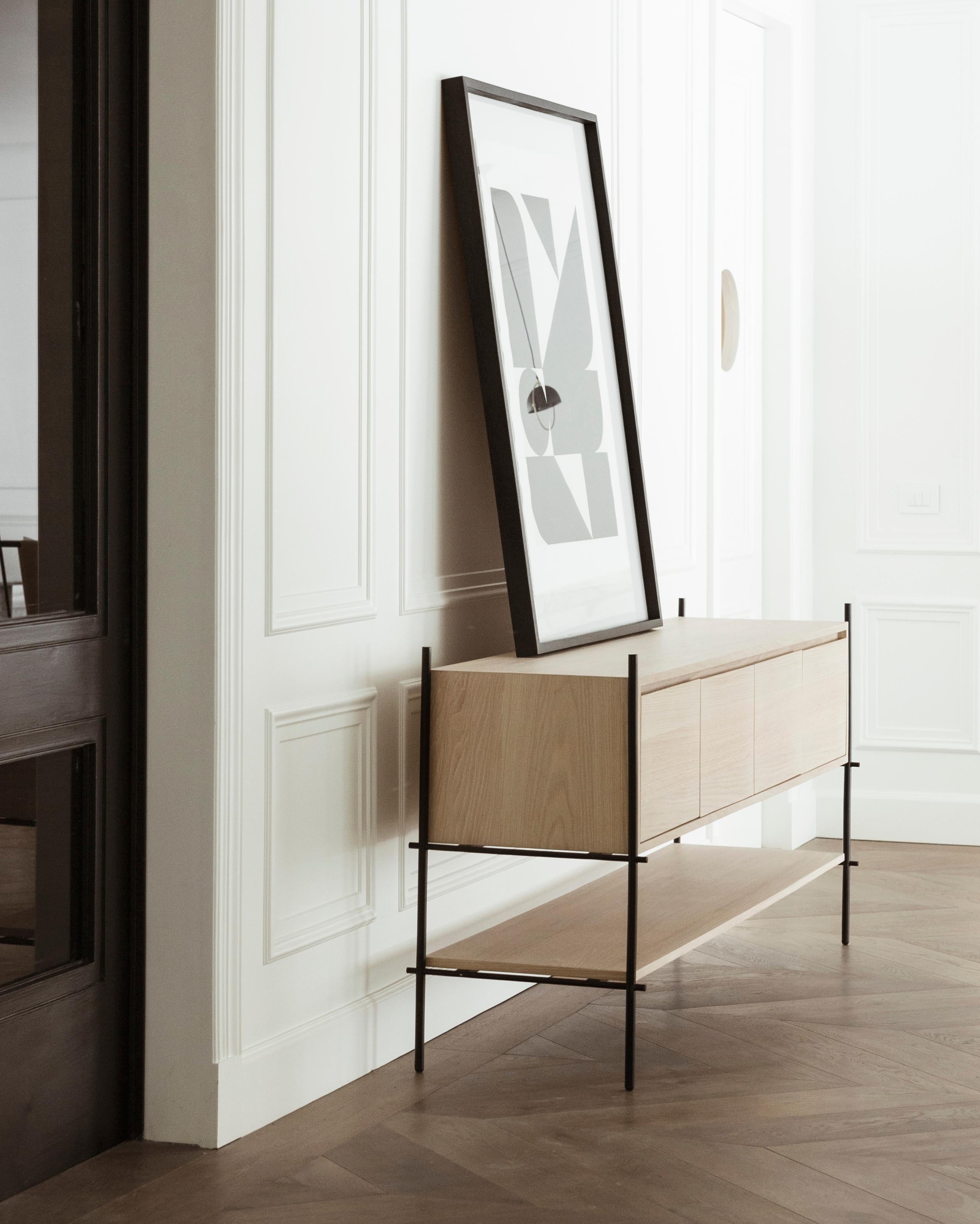 The Credenza Colima follows the concepts of functionalism with its two shelf surfaces and storage area. The electrostatically painted steel structure shows its pure essence, and the wood veneer brings warmth to the piece.   Production time: 6-8