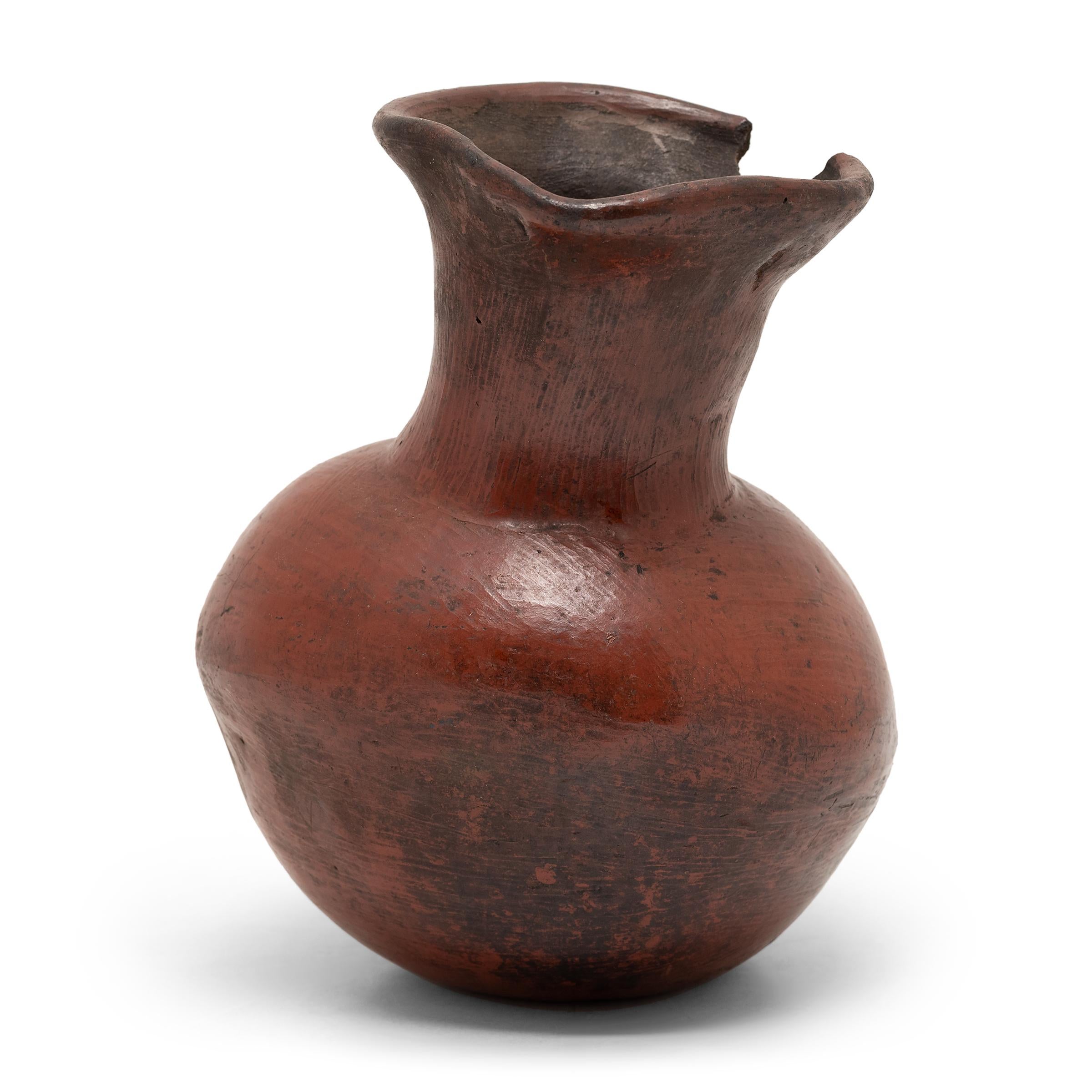 This charming ceramic vessel is attributed to the Colima region of Western Mexico dating back to 300 AD. The vessel boasts a deep red tone and large globular body that comes to a point, mimicking that of a duck, a sacred animal of the Colima