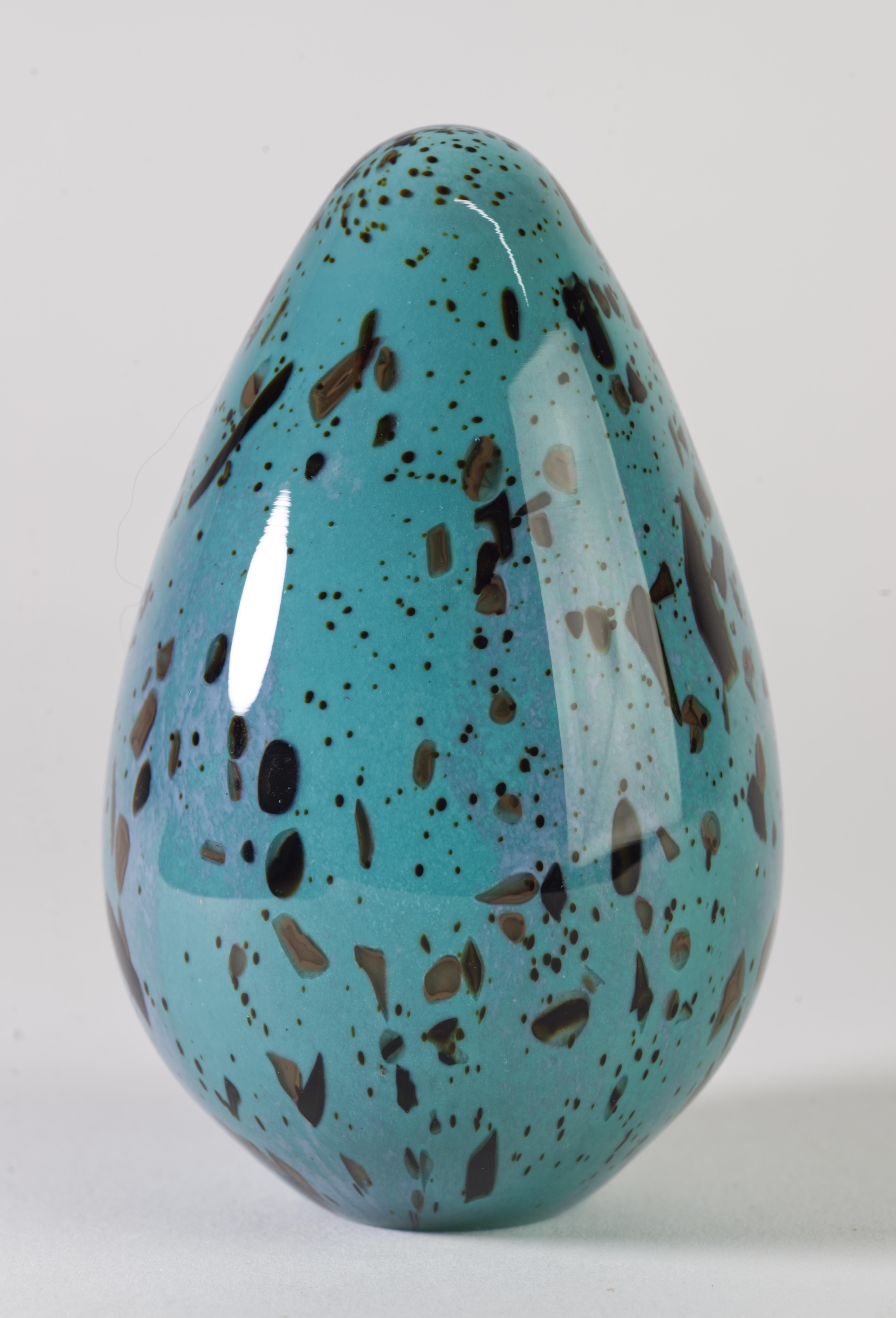  Unusual paperweight was hand blown in elongated ovoid shape. The brown glass murine inclusions in various shapes and sizes were placed in abstract, graphic pattern inside light blue glass gather, with the whole structure enclosed in clear glass in