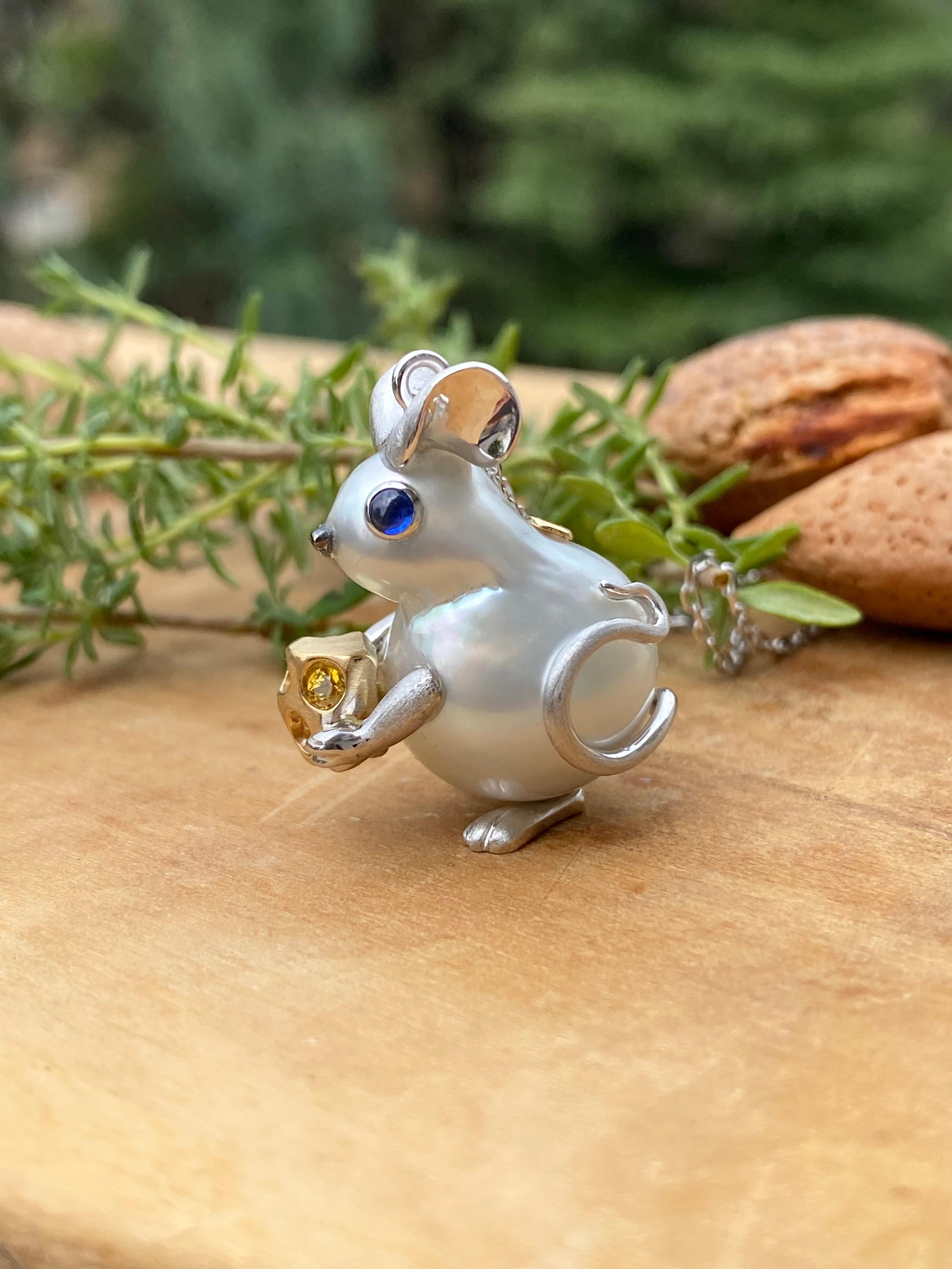 Topolino con perla australiana barocca, oro 18Kt e zaffiri

Questo adorabile topolino prende vita da una splendida perla australiana barocca da 15x21 mm, la cui forma irregolare e naturale ha ispirato la sua creazione. Con le zampette anteriori