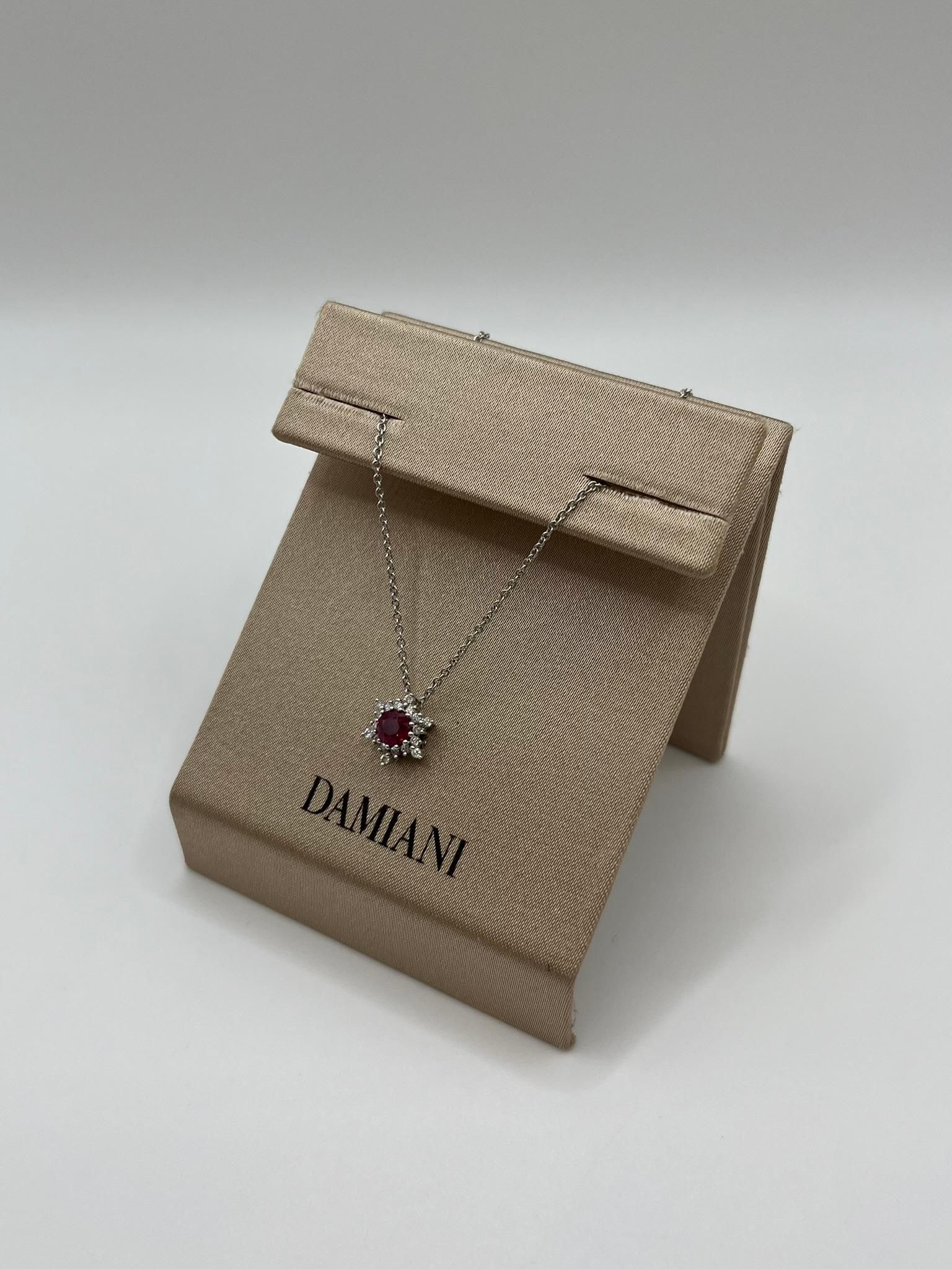Raffiniertes Damiani-Collier aus 18 kt. Weißgold mit einem Anhänger in Form einer Schneeflocke, in deren Mitte ein leuchtender roter Rubin im Rundschliff sitzt, umrahmt von einem Kranz weißer Diamanten im Brillantschliff. Dieses Schmuckstück ist ein