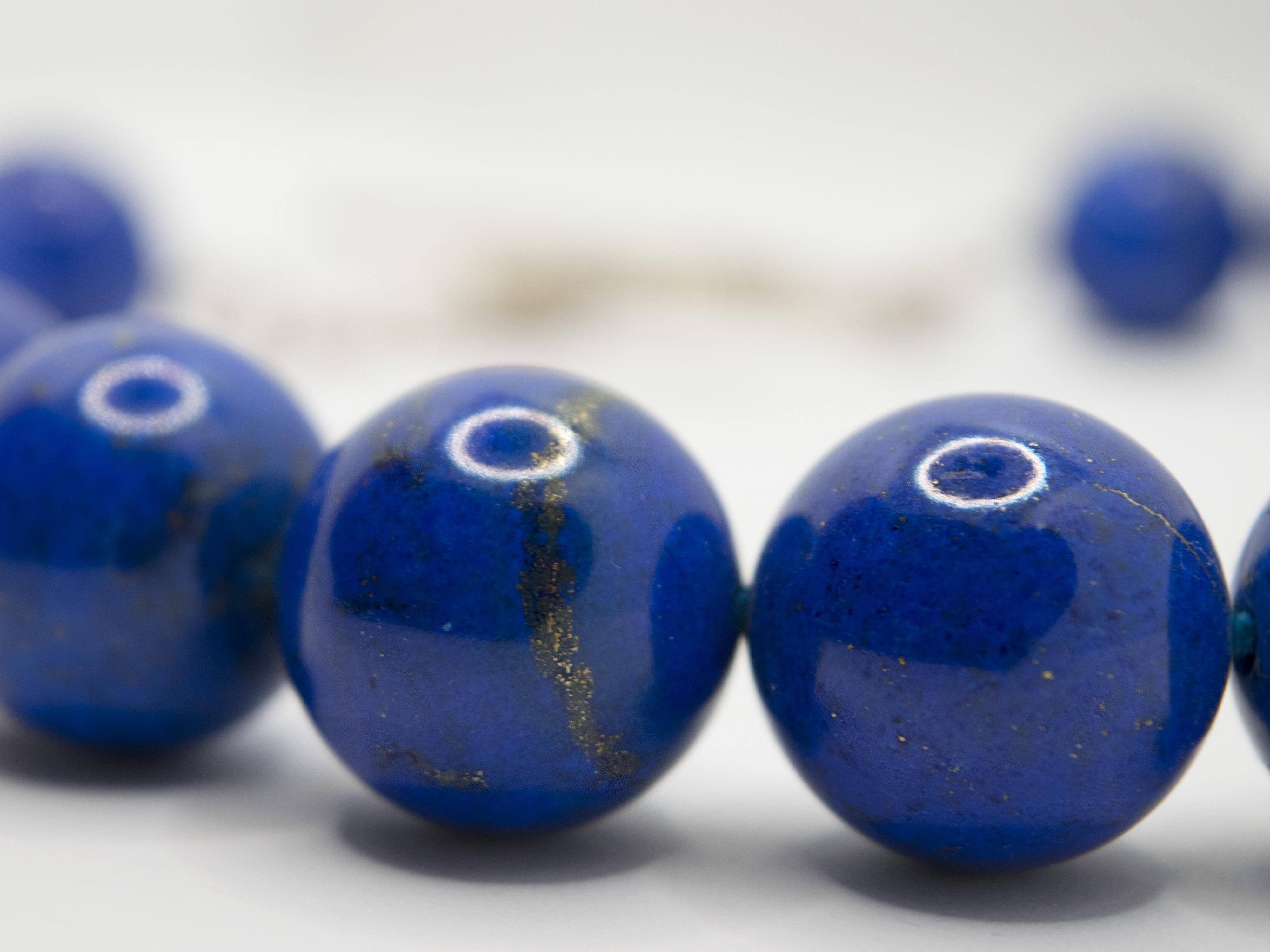 Collier impressionnant composé de sphères de lapis-lazuli d'un diamètre de 2,00 cm
Les pierres sont d'un beau bleu profond avec  veines d'or caractéristiques.
Le fermoir est en argent, le design des années 60 rend ce bijou unique et à la mode.
Ce