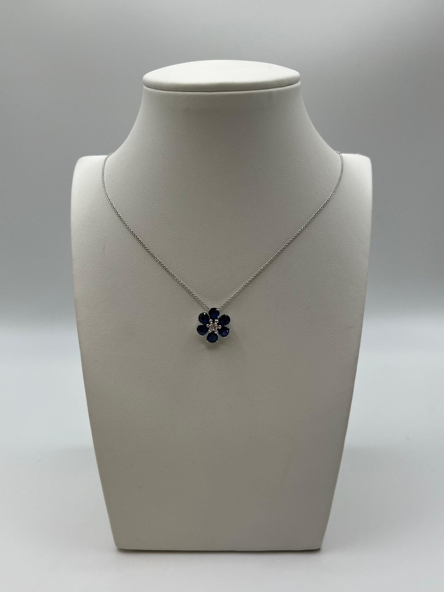 Splendida collana Leopizzo realizzata in Italia, in oro bianco 18 kt. 750/00. Il ciondolo a Fiore è formato da 6 zaffiri blu naturali taglio a goccia a simularne i petali, il peso totale è di 2.08 ct. , mentre il centro è realizzato con un diamante