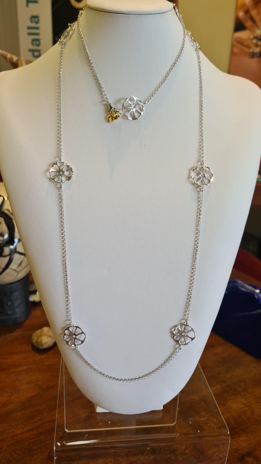 Collar largo de disco calado, realizado a mano con la antigua técnica de fundición a la cera perdida o a la cera perdida, en plata de ley 925 chapada en rodio y paladio.
Este collar se inspira en un pequeño disco perforado, tallado en marfil de