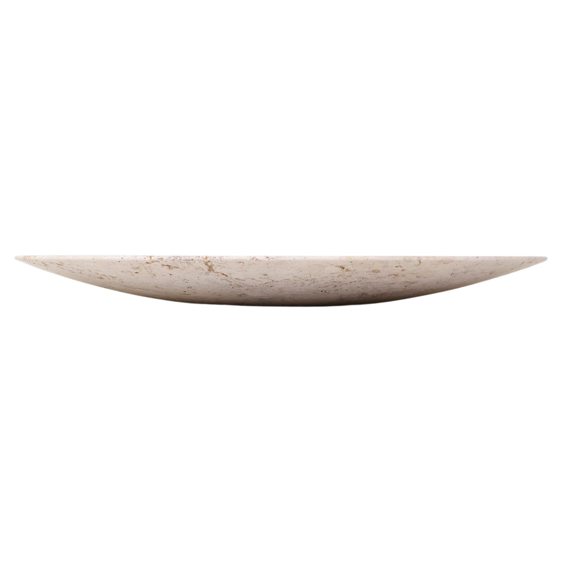 Conçue par Space Copenhagen, cette assiette polie à la main fait partie de la série Collect, une ligne de produits d'ameublement et d'objets pour la maison magnifiquement fabriqués. Fabriquée à partir de travertin beige, chaque plaque est une pièce